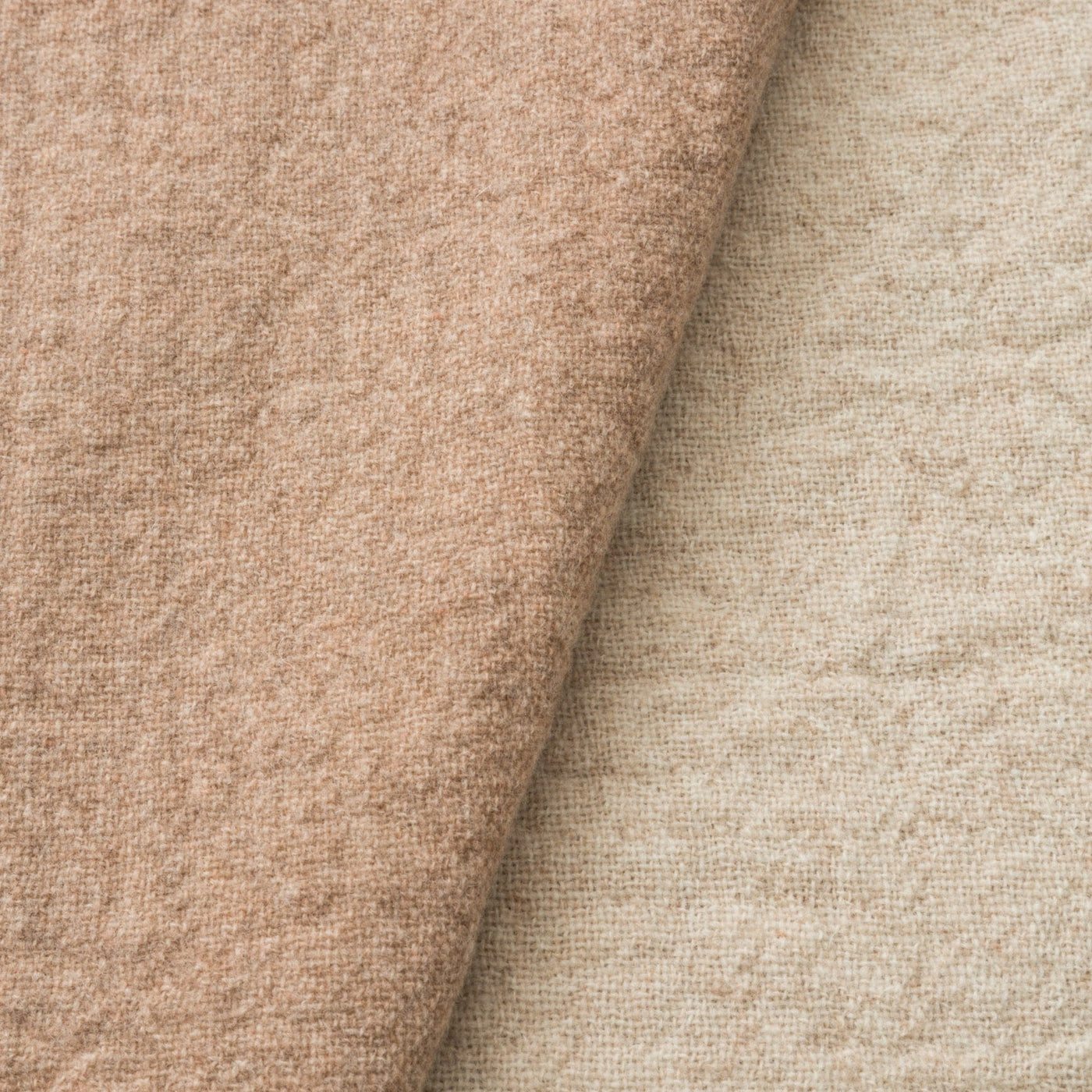 Close-up of two Lanerossi Dioniso throws in blush and ivory, showing bouclé texture contrast.