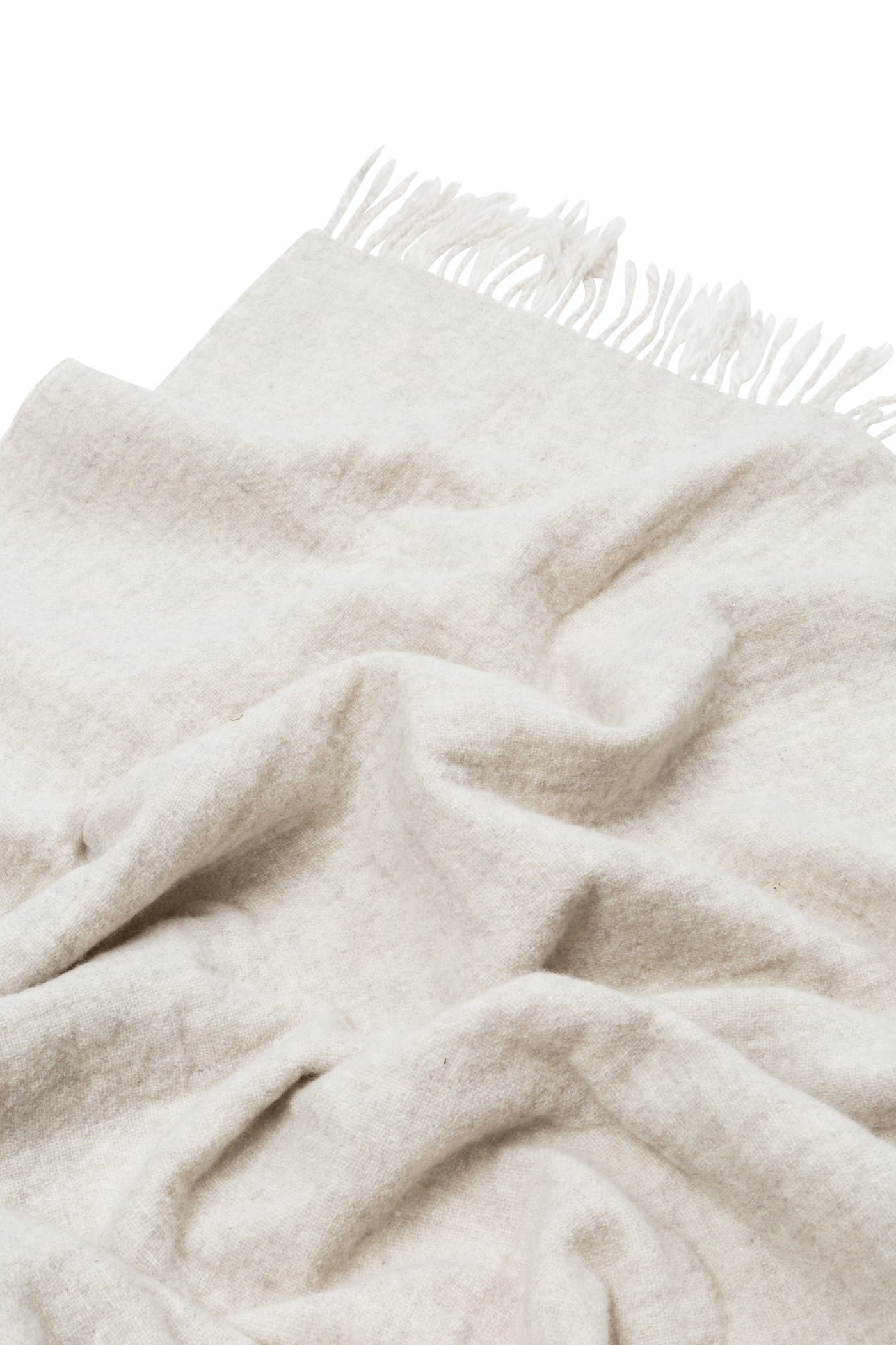 Close-up of draped ivory Lanerossi Dioniso throw with knotted fringe trim.
