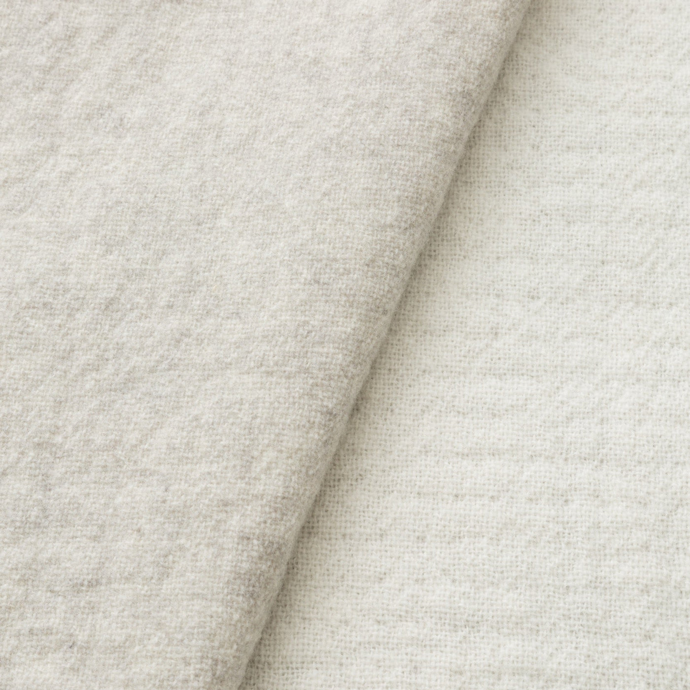 Close-up of Lanerossi Dioniso throw fabric fold, showing oatmeal heathered wool texture.