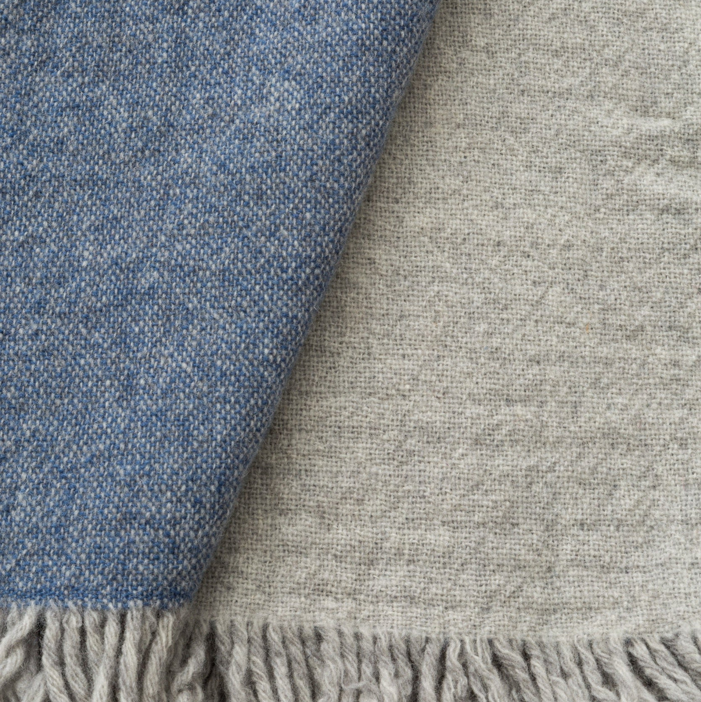 Close-up of Lanerossi Dioniso throw showing blue and grey reversible wool weave with fringe.