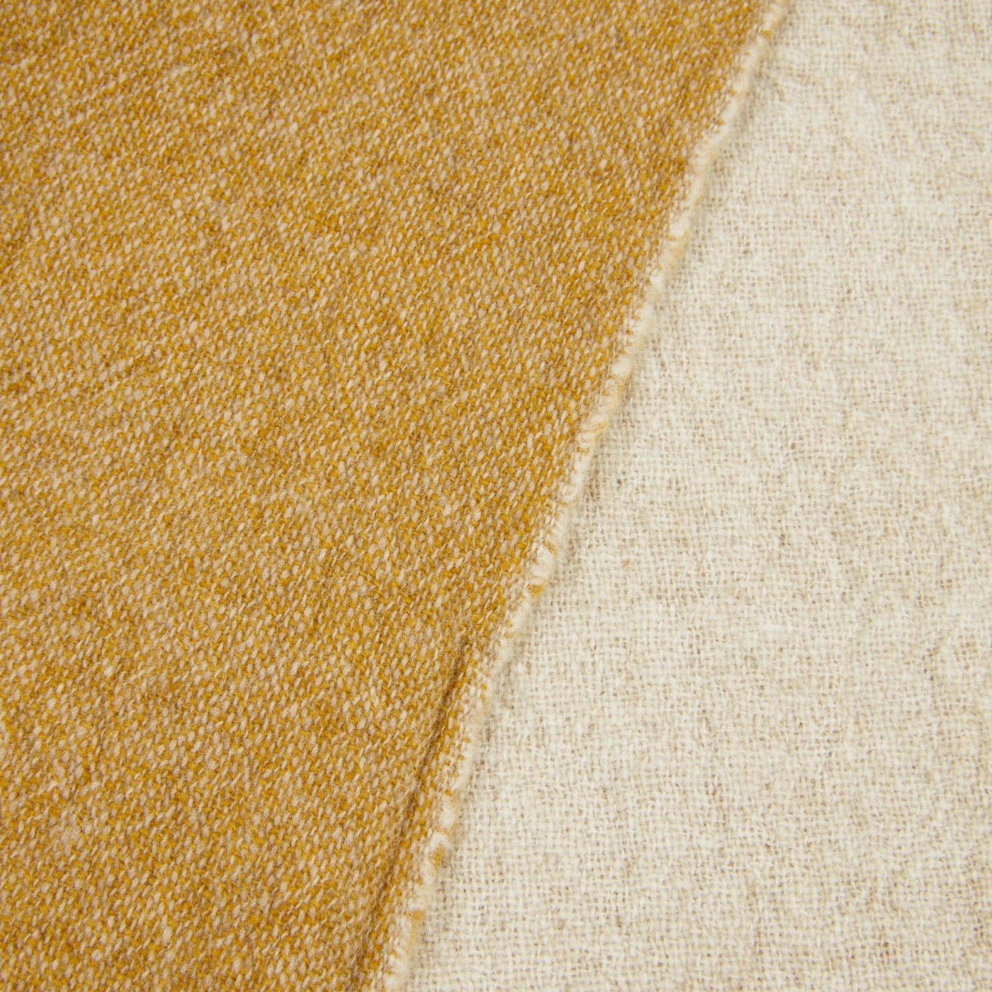 Close-up of Lanerossi Dioniso throw showing saffron and ivory reversible fabric texture.