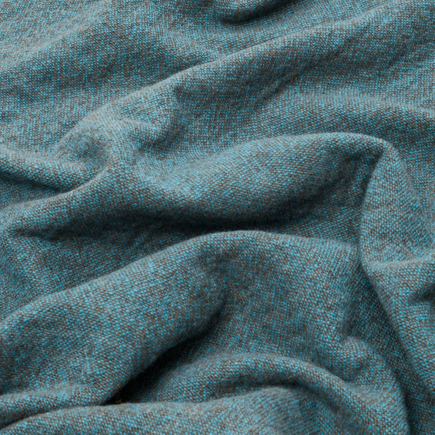 Close-up of draped teal melange wool throw showing flecked weave texture.