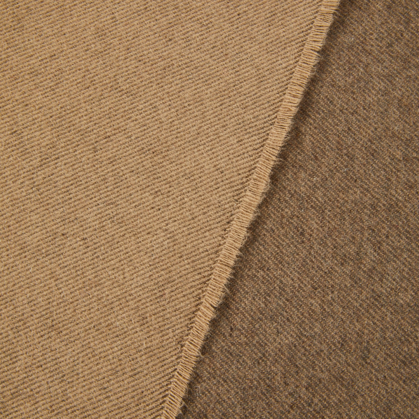 Close-up of camel wool throw showing blanket stitch edge and fine ribbed weave texture.