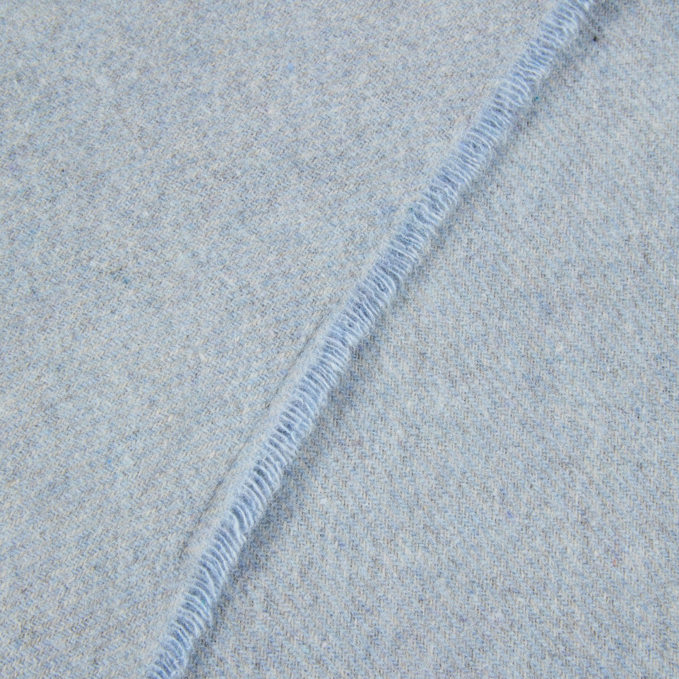 Close-up of Lanerossi Everest Check throw's pale blue whipstitch edge detail.