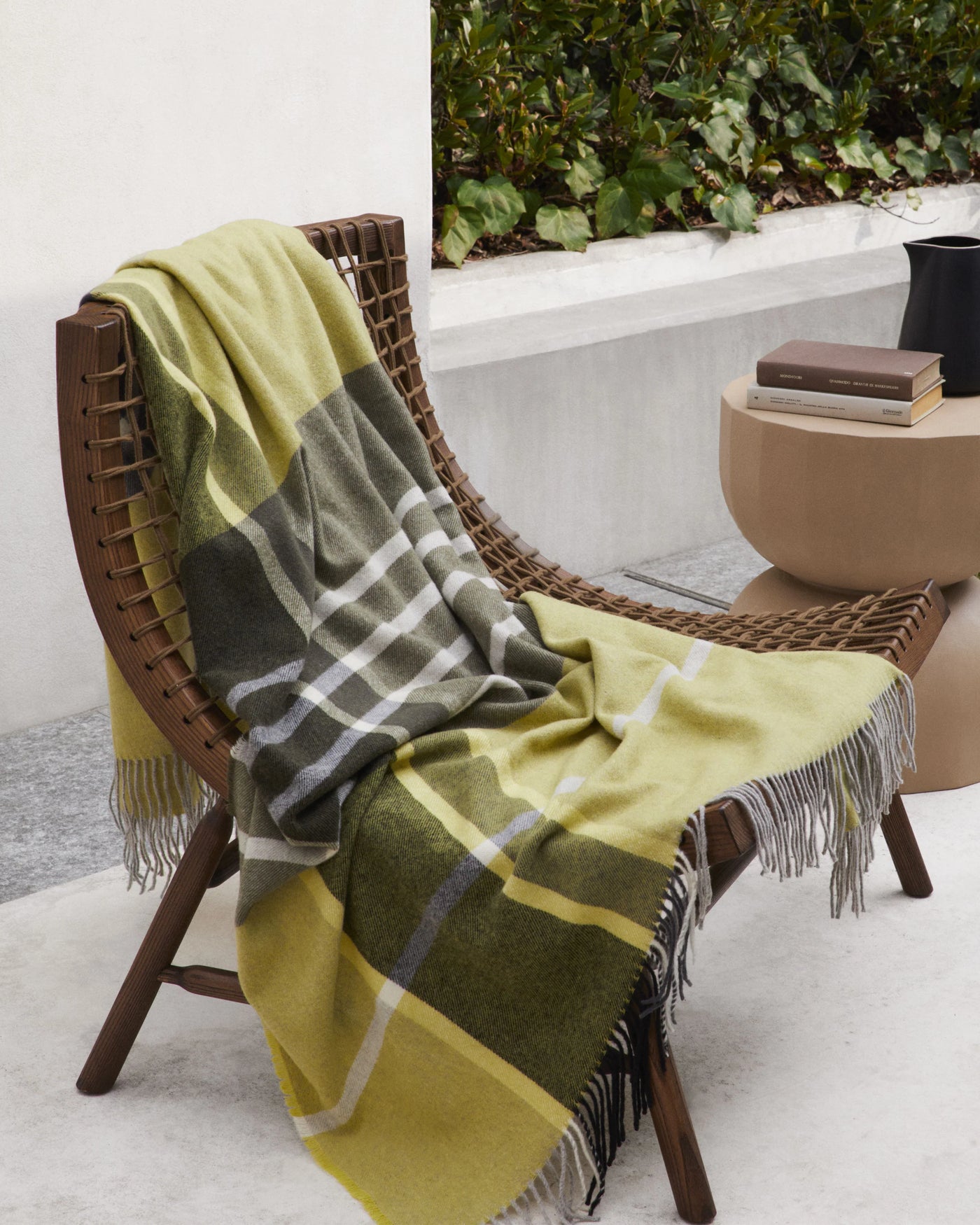 Everest Check throw in chartreuse and olive plaid draped over outdoor woven chair.
