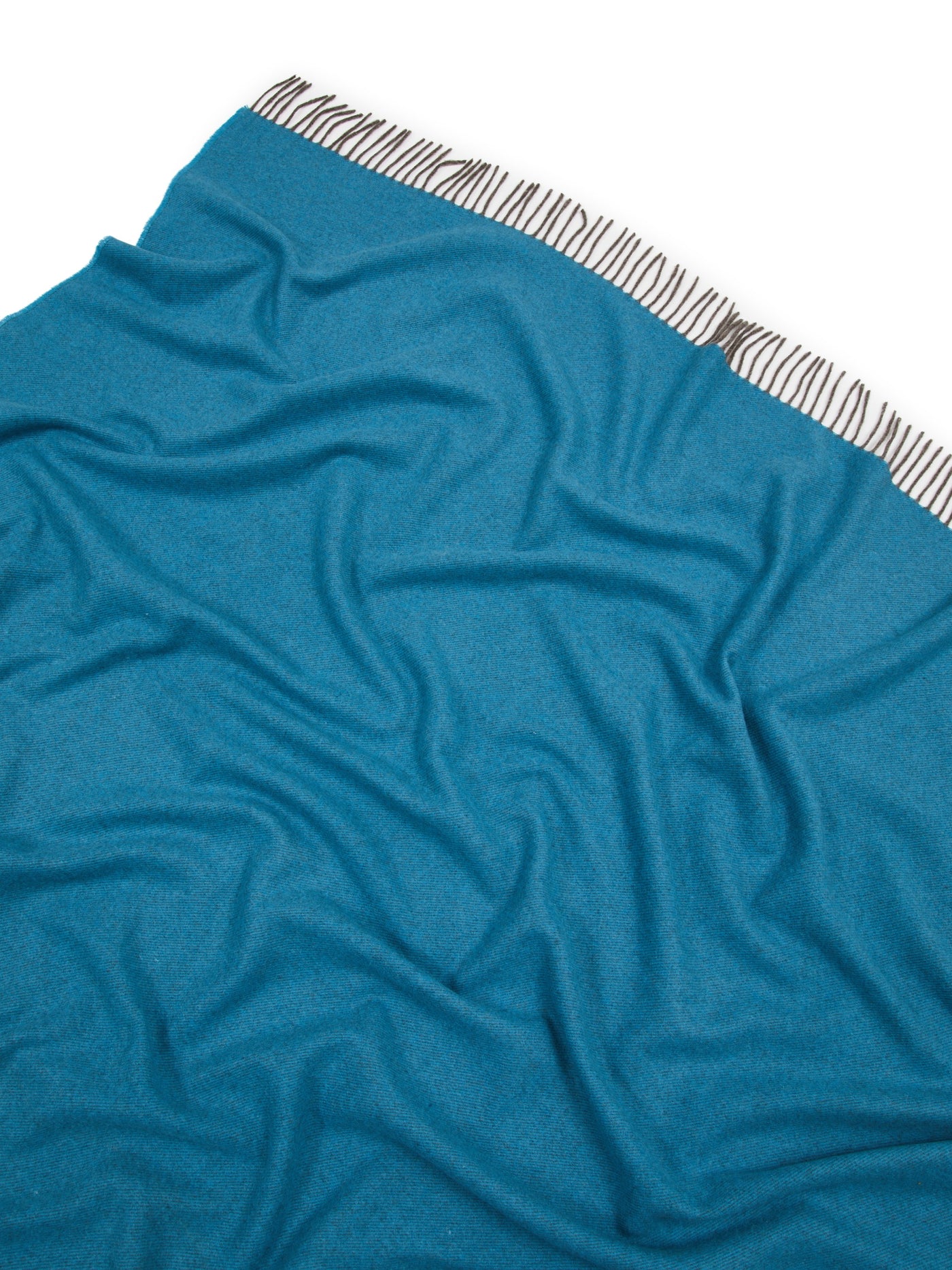 Close-up of Lanerossi Everest Colour throw in teal, showing fringe trim detail.