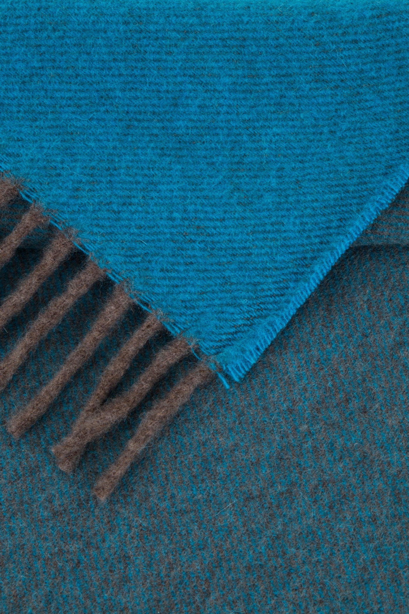 Close-up of Lanerossi Everest Colour throw corner showing teal herringbone weave and brown fringe trim.