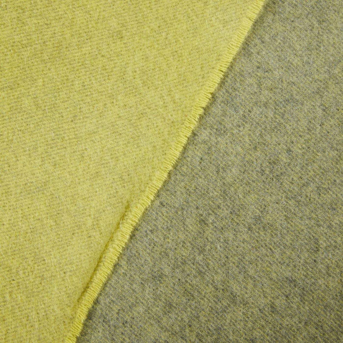 Close-up of Lanerossi Everest Colour throw folded edge, showing citron and sage reversible wool weave.