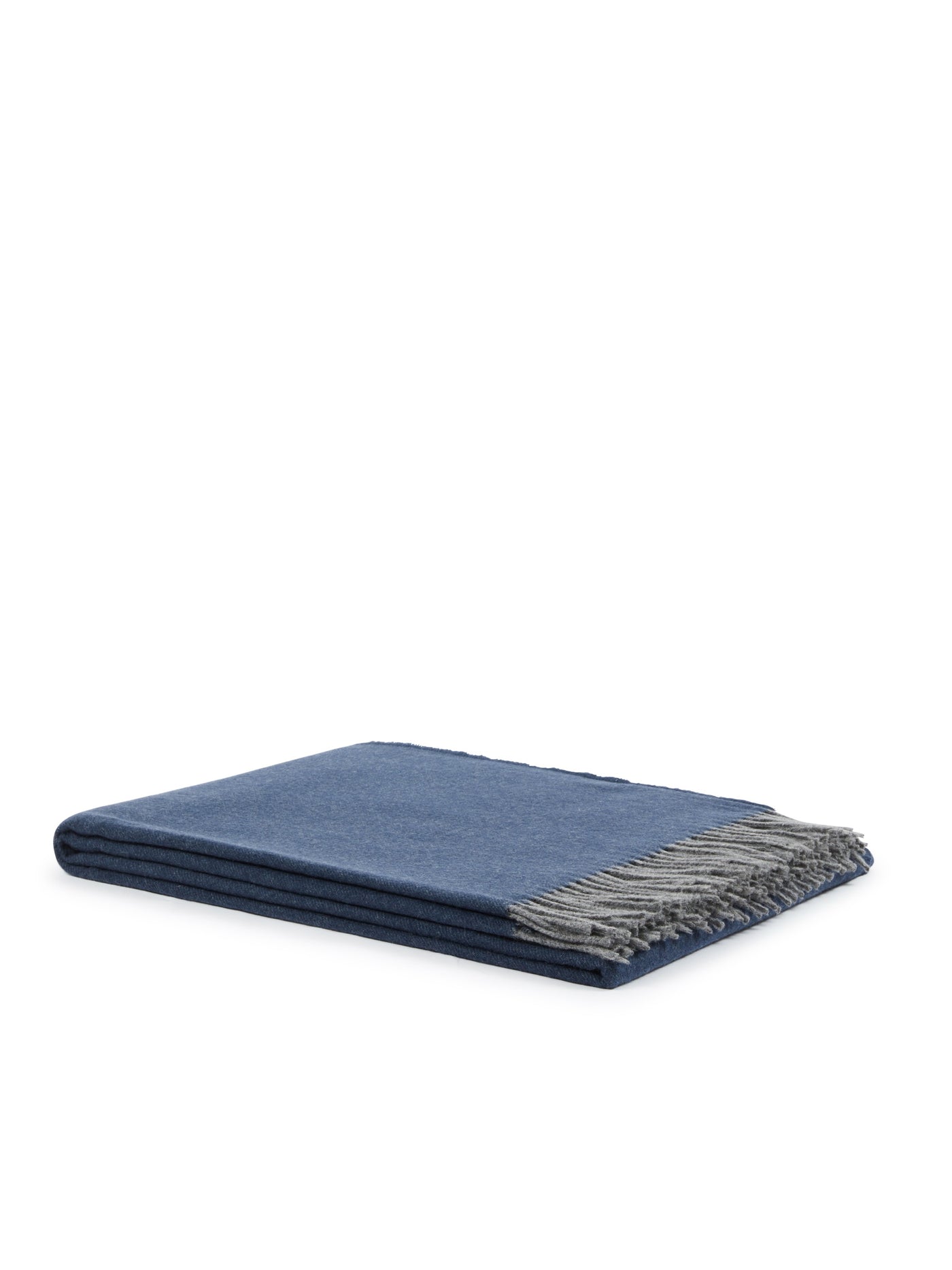 Close-up of folded navy blue throw with contrast grey fringe trim.
