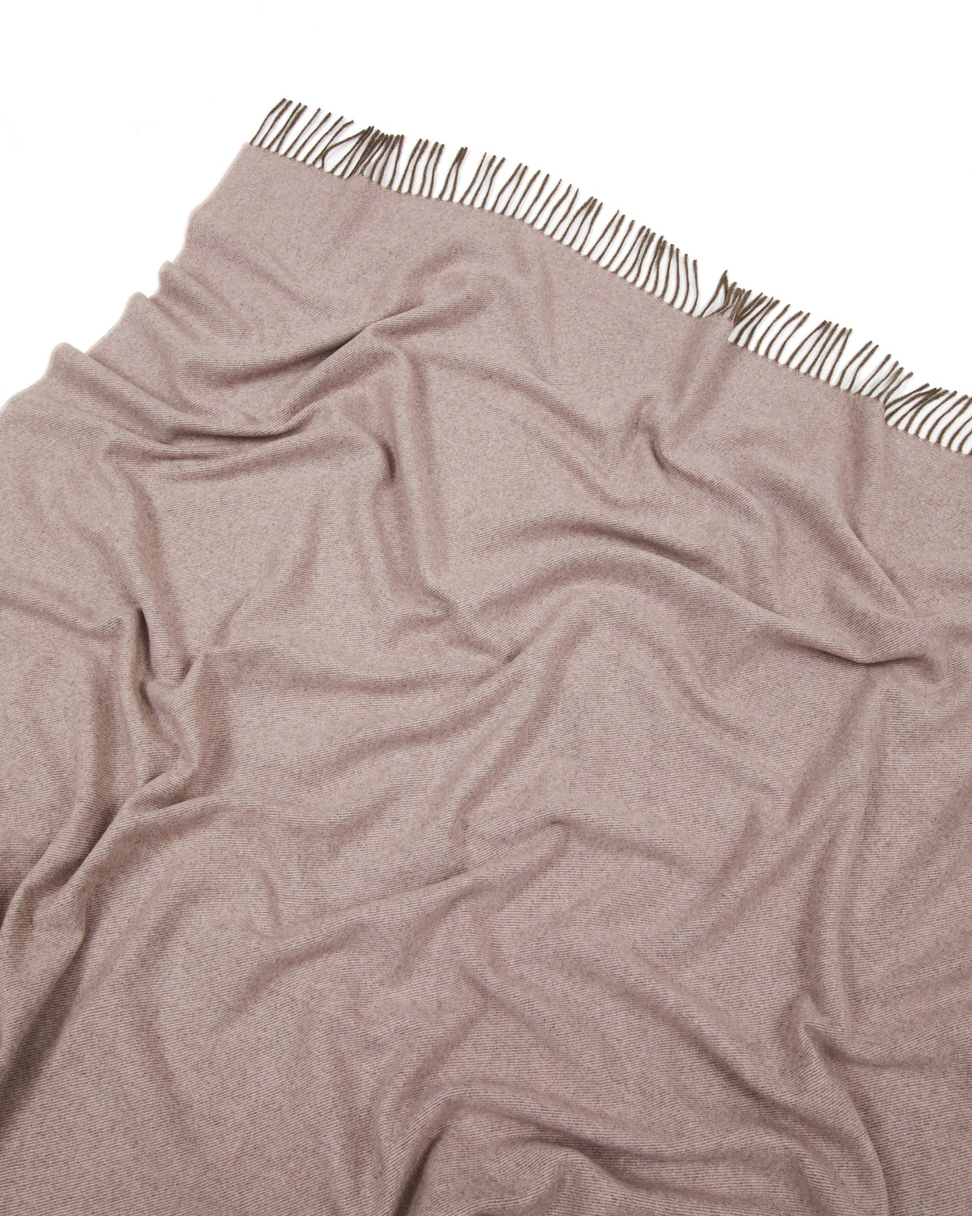 Lanerossi Everest Colour throw corner detail showing fringe trim against blush fabric.