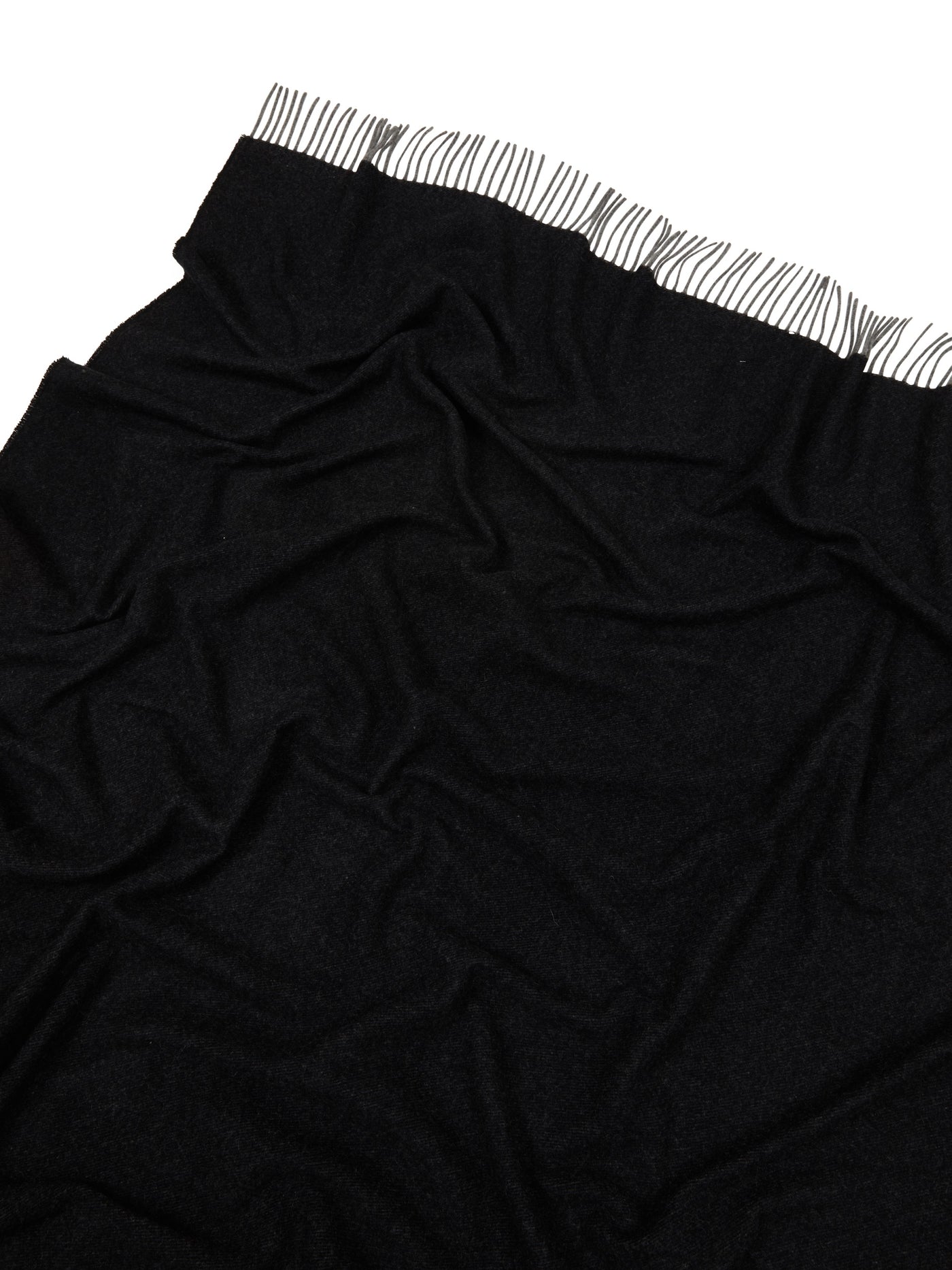 Close-up of black Lanerossi Everest Colour throw showing draped fabric and striped fringe edge.