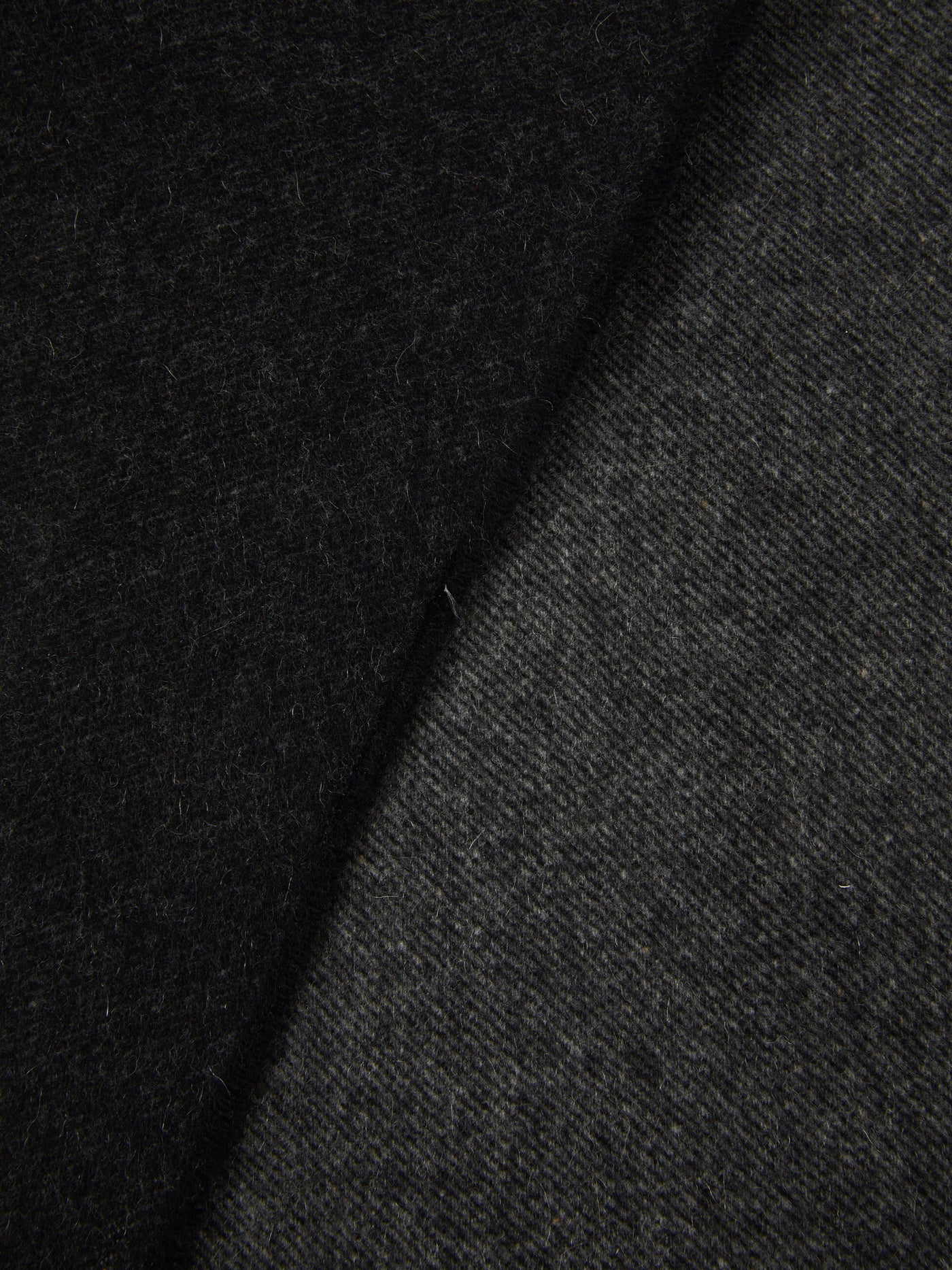 Close-up of Lanerossi Everest Colour throw folded edge, charcoal wool fabric texture.