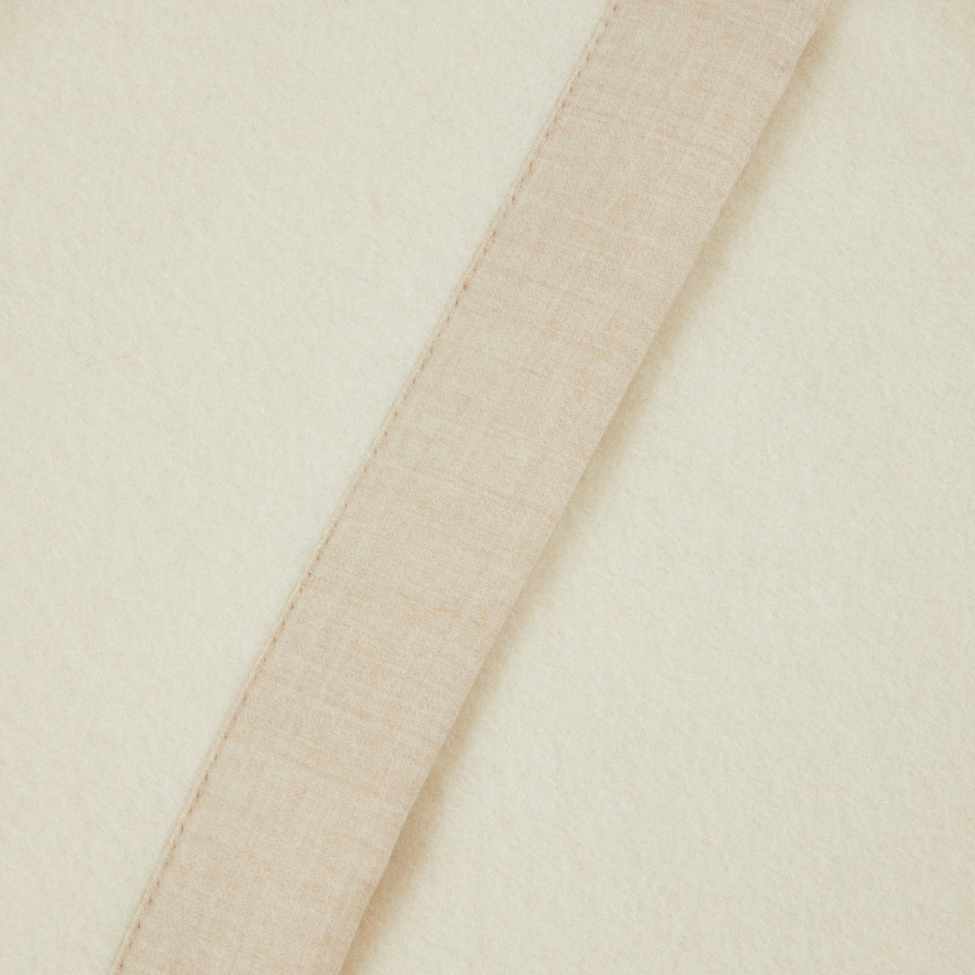 Close-up of Lanerossi Geisha blanket hem, showing contrast linen binding on ivory wool.