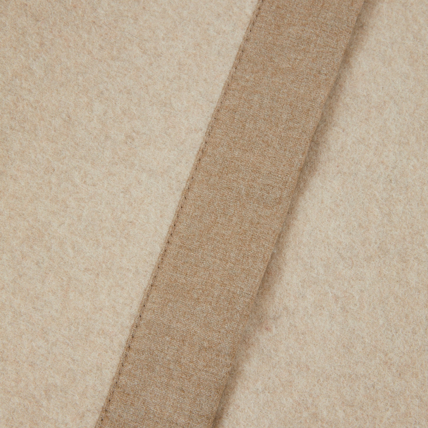 Close-up of Lanerossi Geisha blanket ivory wool with contrast camel stitched border trim.