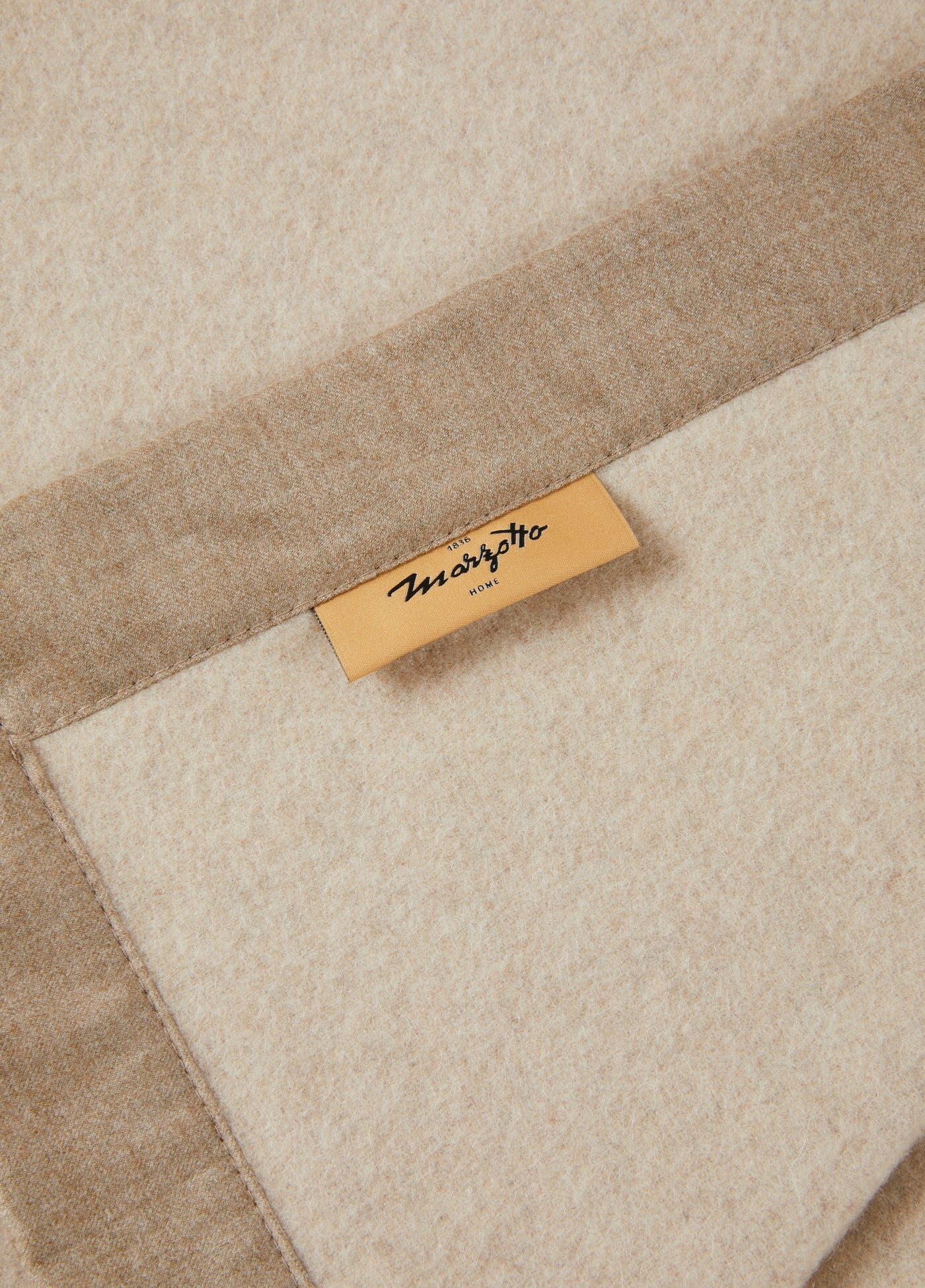 Close-up of Lanerossi blanket corner showing ivory wool, taupe border, and woven label.
