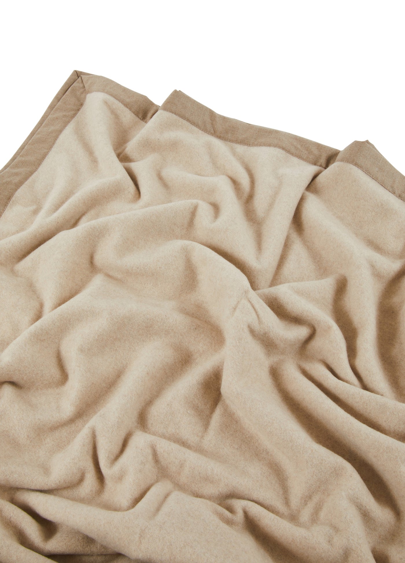 Close-up of Lanerossi Geisha blanket in sand, showing soft draped cashmere-blend fabric with contrast border.