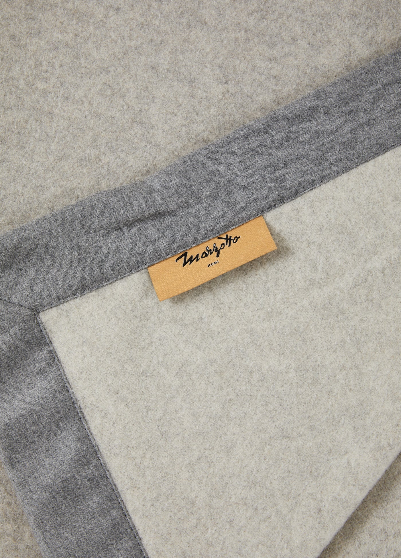 Close-up of Lanerossi blanket corner showing grey border, ivory interior, and woven label.