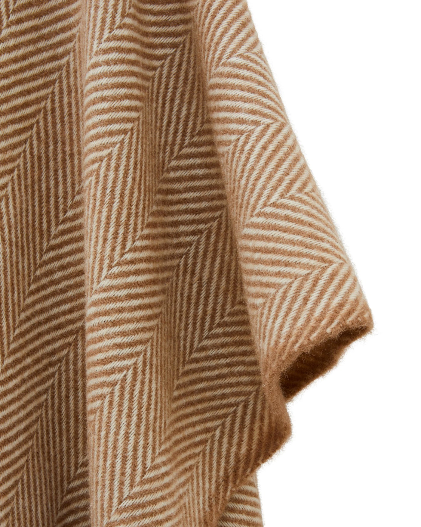 Close-up of camel and ivory herringbone weave on a draped Lanerossi Iseo Spina poncho corner.
