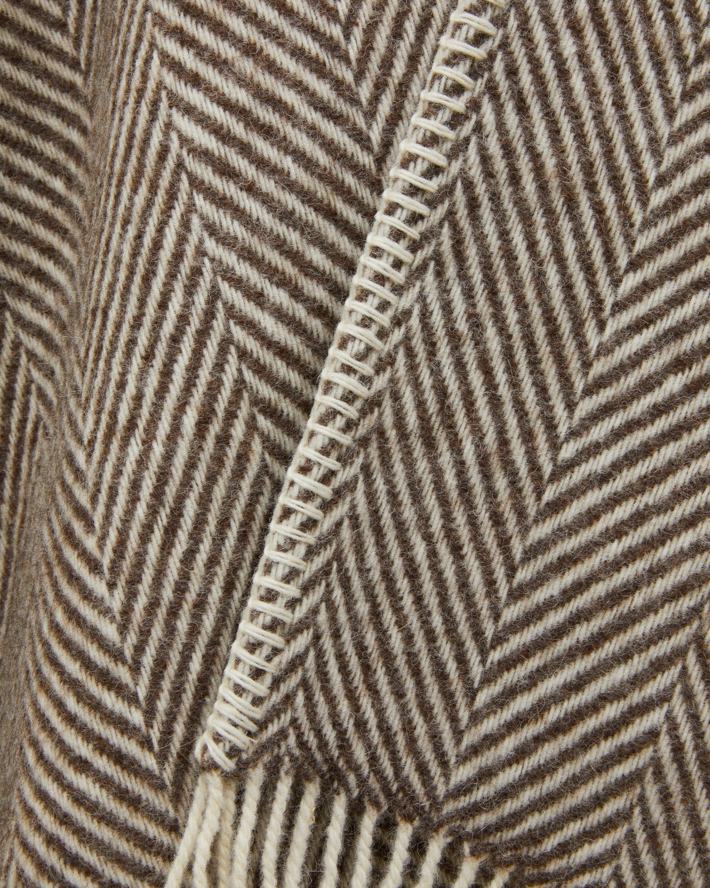 Close-up of Lanerossi Iseo Spina poncho blanket-stitch edge in taupe herringbone wool.