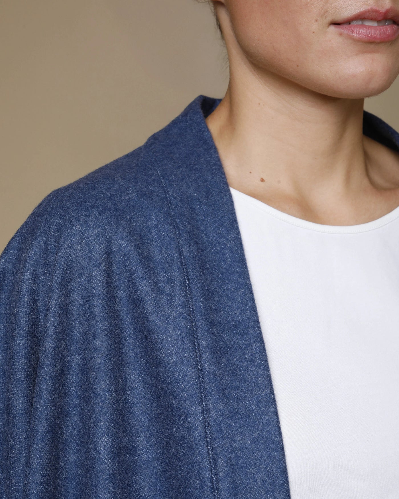 Close-up of Lanerossi Extrafine Merino Kimono Jacket in denim blue, draped over shoulder.