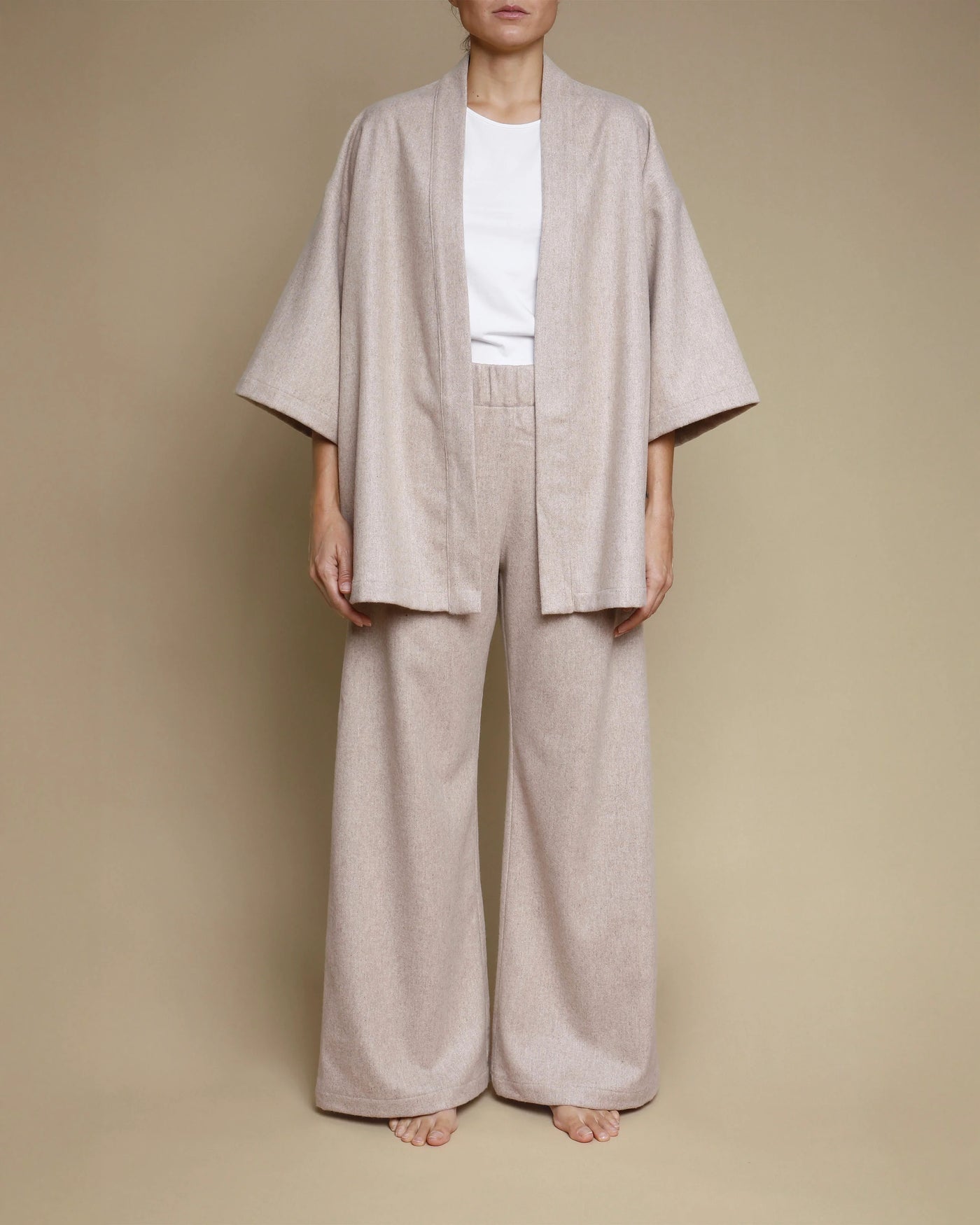 Oatmeal merino kimono jacket styled open over wide-leg trousers, front view.