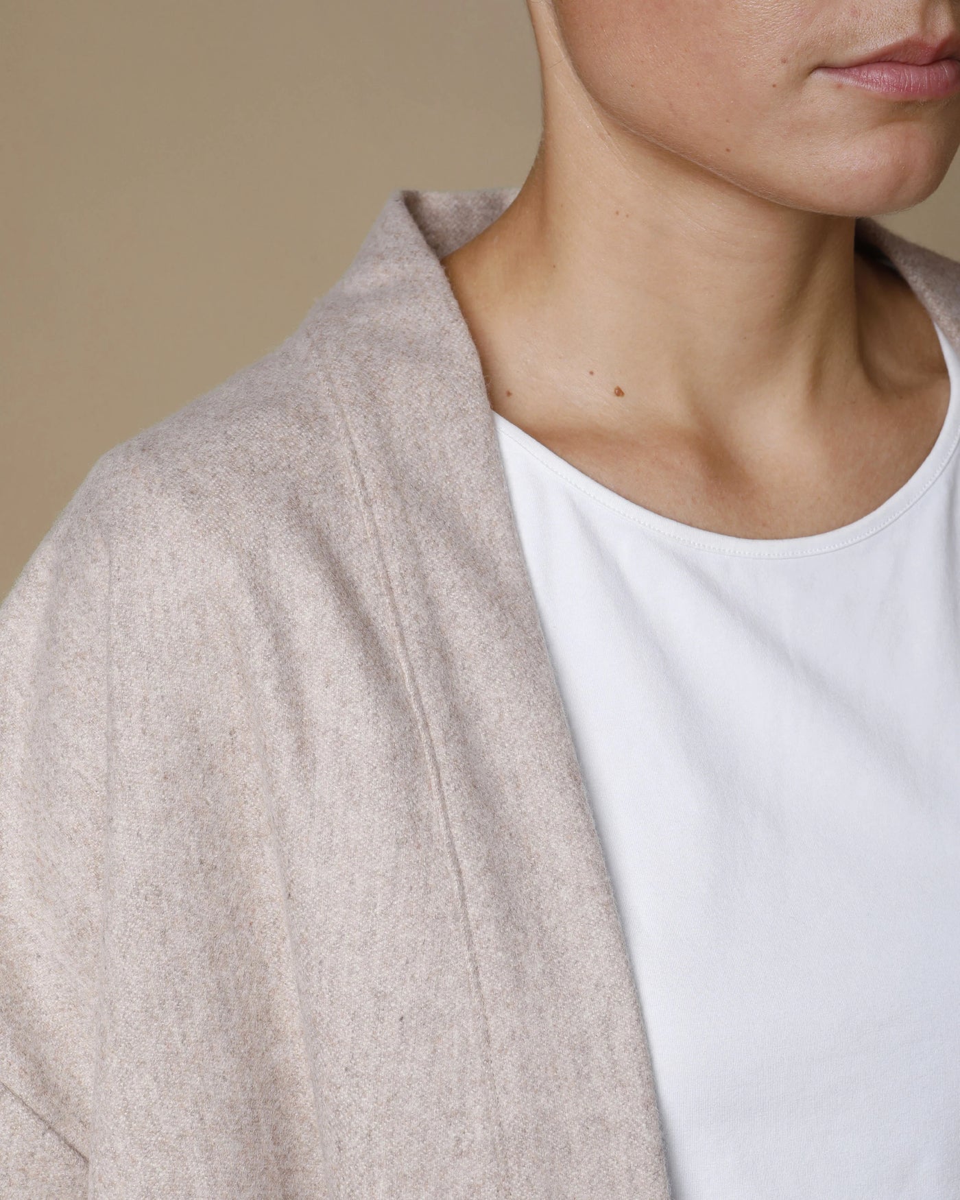 Close-up of oatmeal extrafine merino kimono jacket collar and shoulder detail on model.