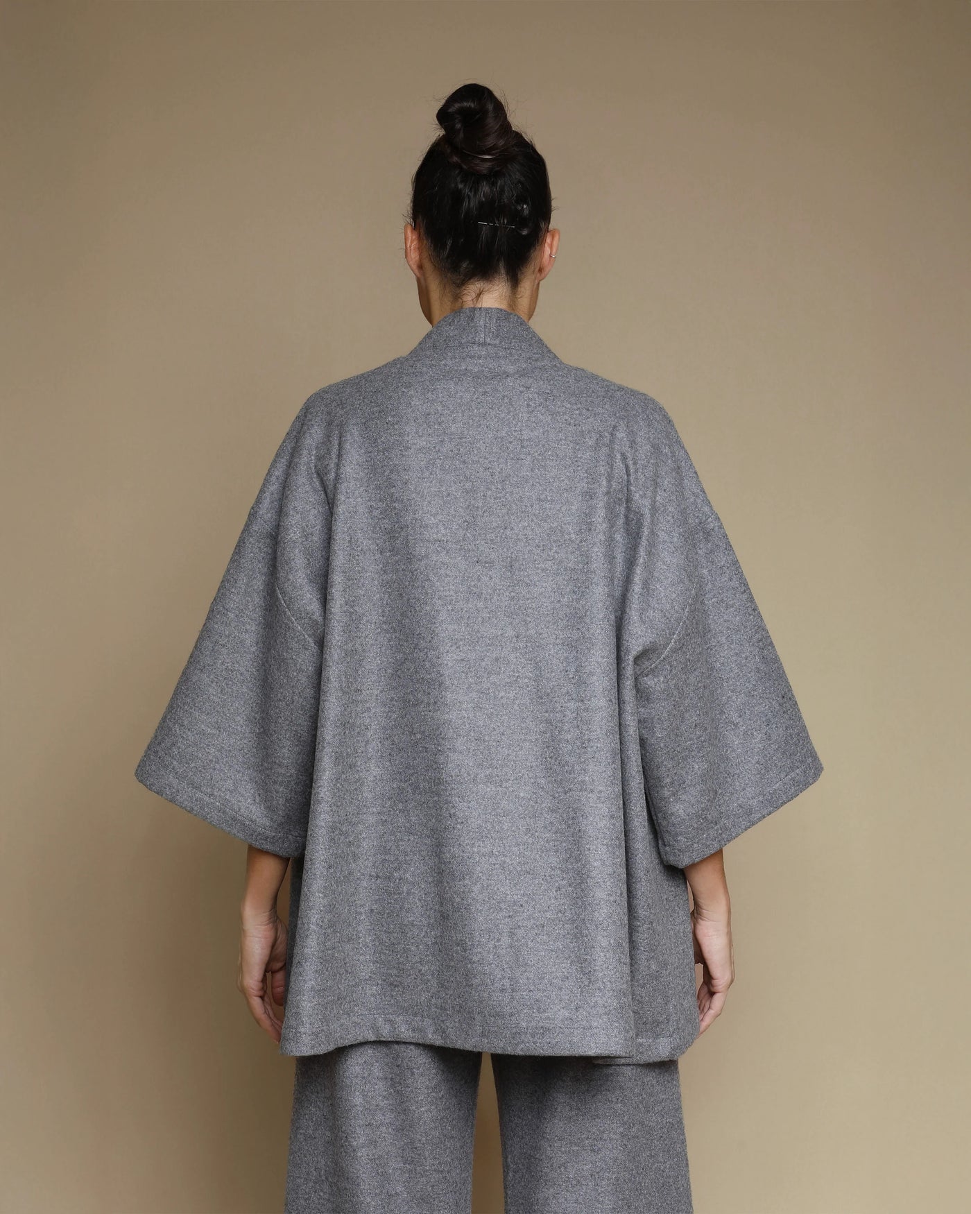 Back view of Lanerossi Extrafine Merino kimono jacket in grey, wide sleeves, coordinating trousers.