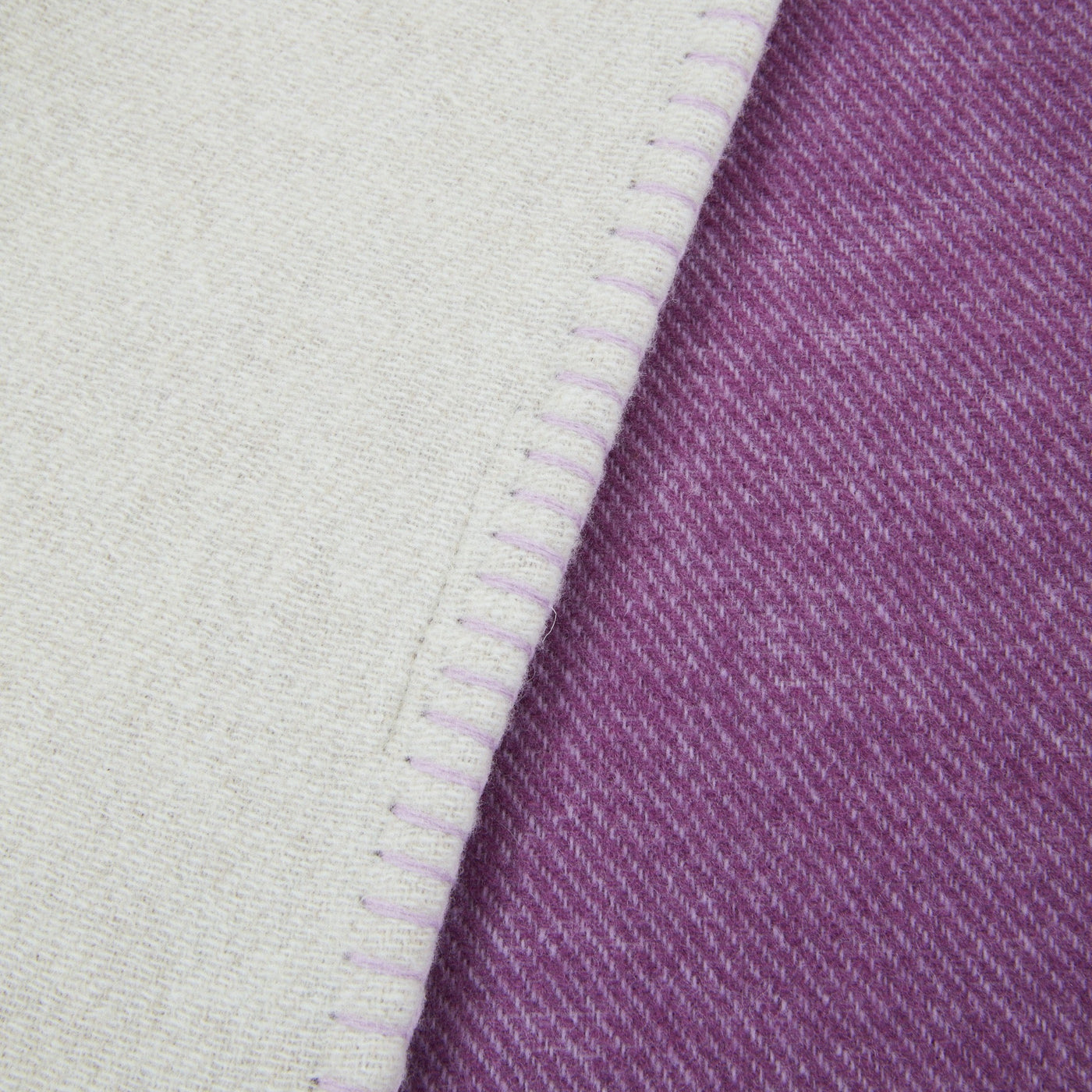 Close-up of Lanerossi Metropolis throw hem, showing ivory and violet reversible wool weave.