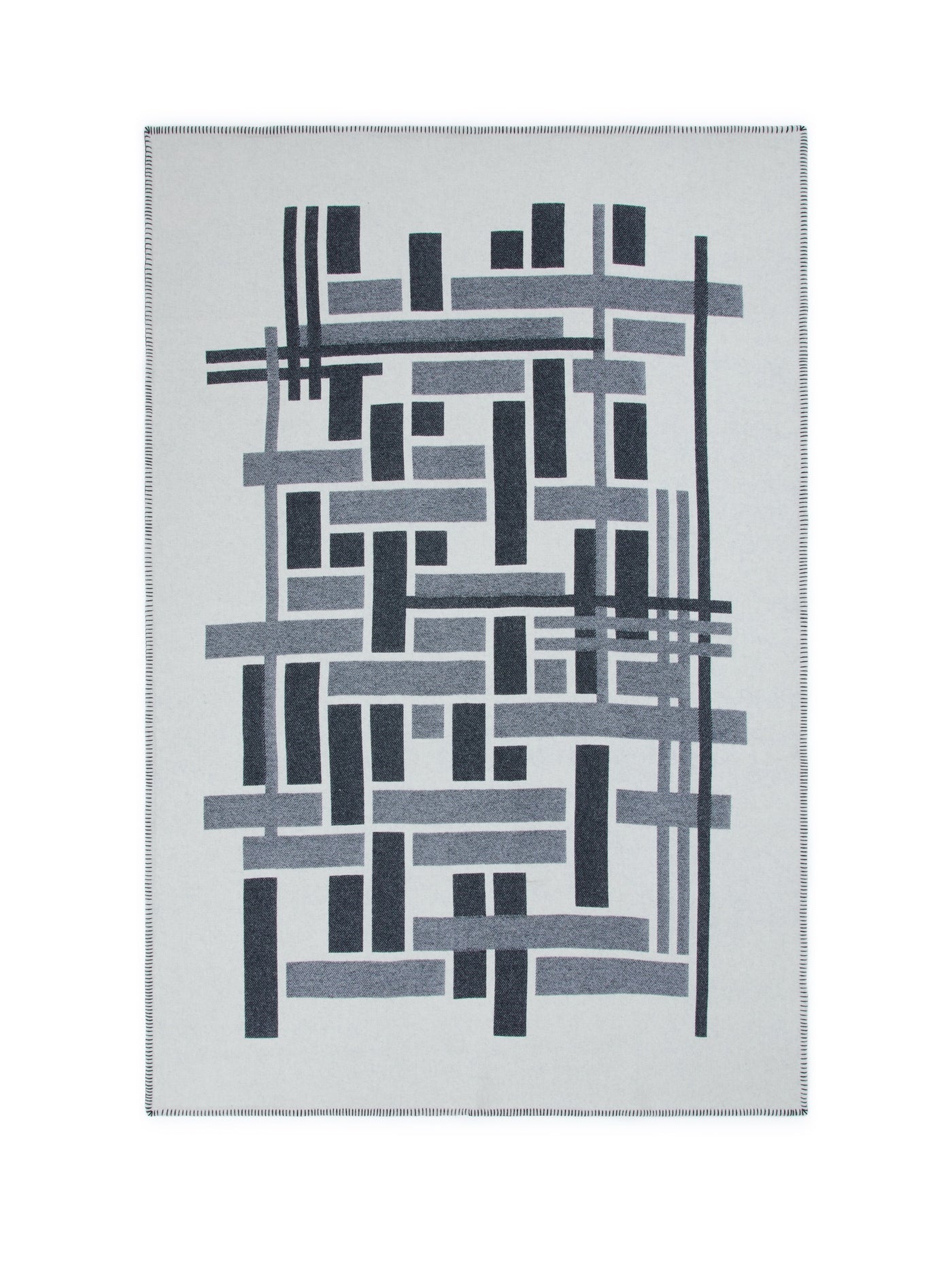 Metropolis throw laid flat, geometric grid pattern in charcoal and grey on silver ground.