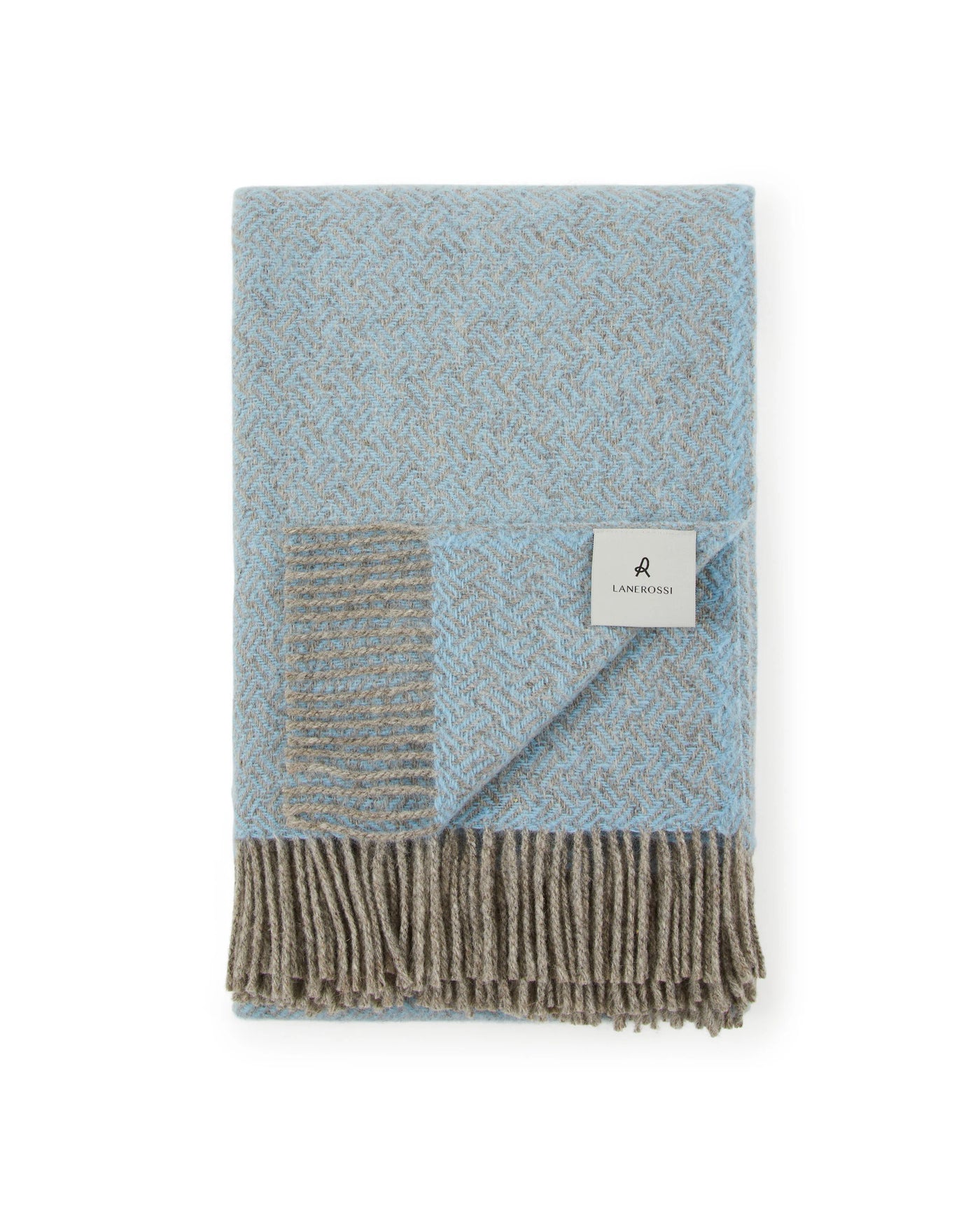 Close-up of folded Lanerossi Mata Mata throw in sky blue with taupe fringe and woven label.
