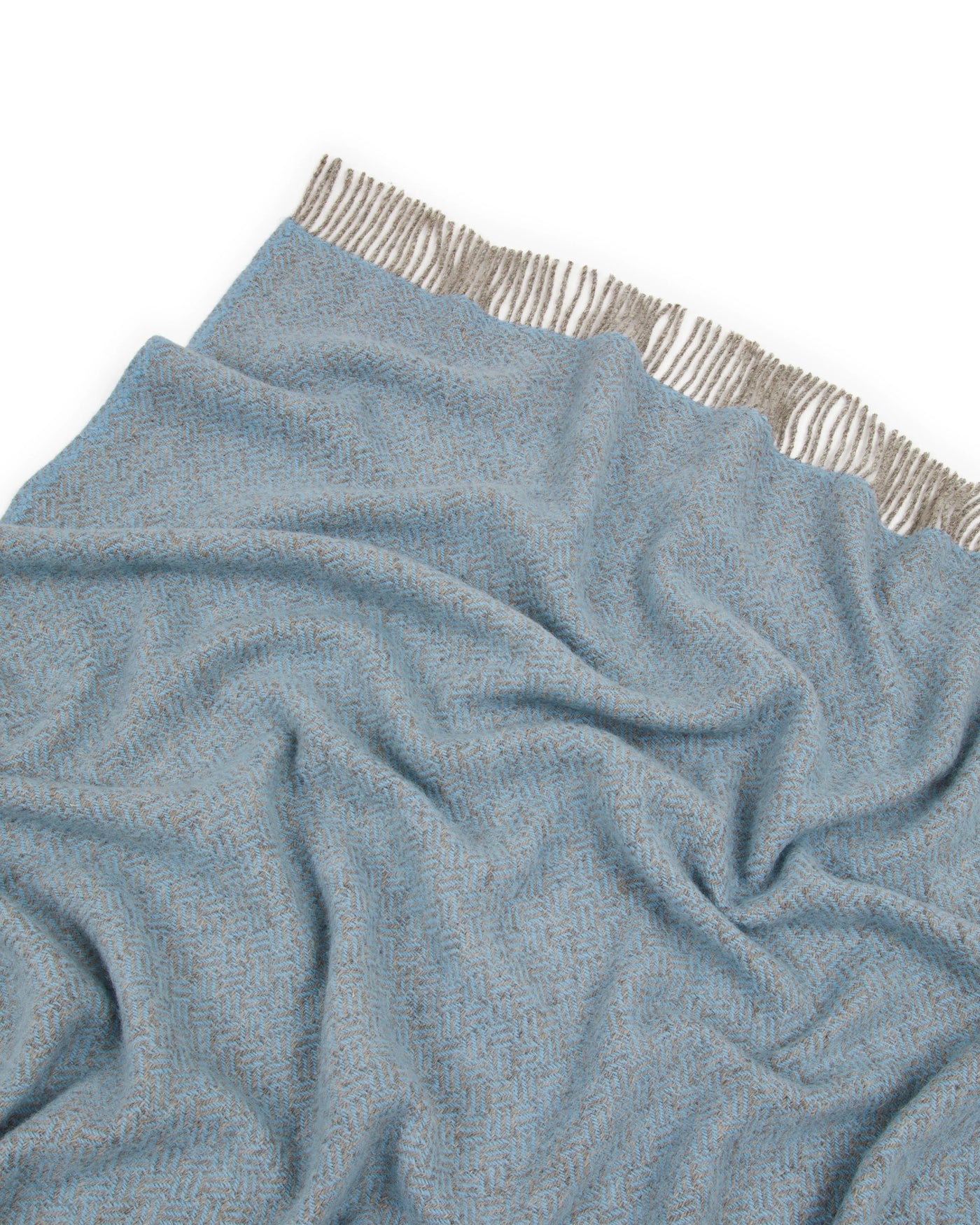 Close-up of Lanerossi Mata Mata throw in sky blue herringbone weave with natural fringe trim.