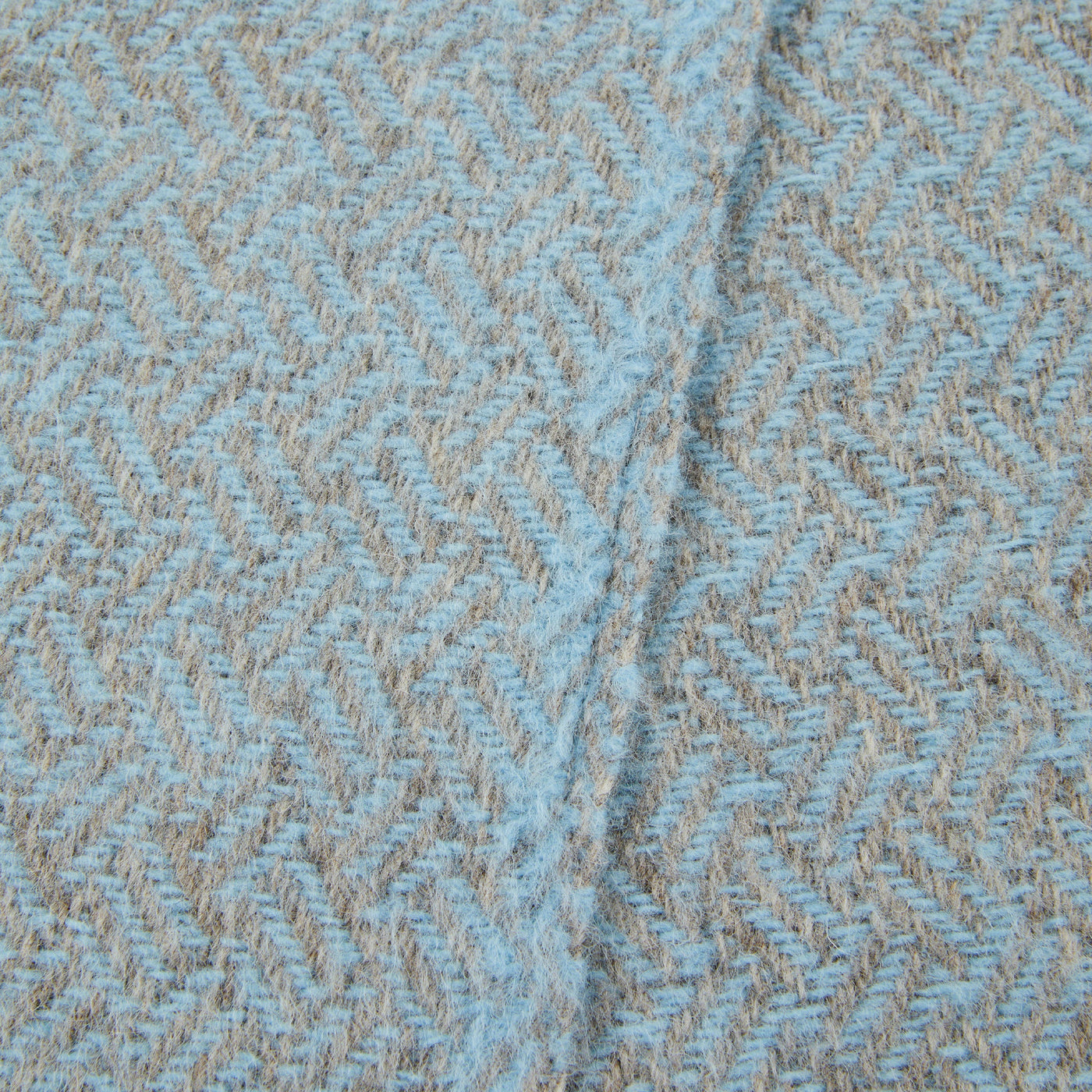 Close-up of Lanerossi Mata Mata throw herringbone weave in sky blue and natural tan.