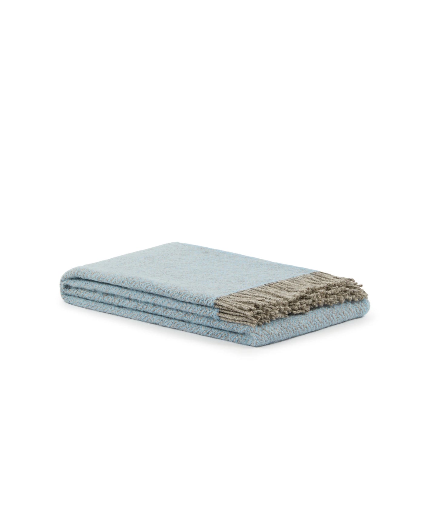 Close-up of folded Mata Mata throw in sky blue with taupe knotted fringe detail.