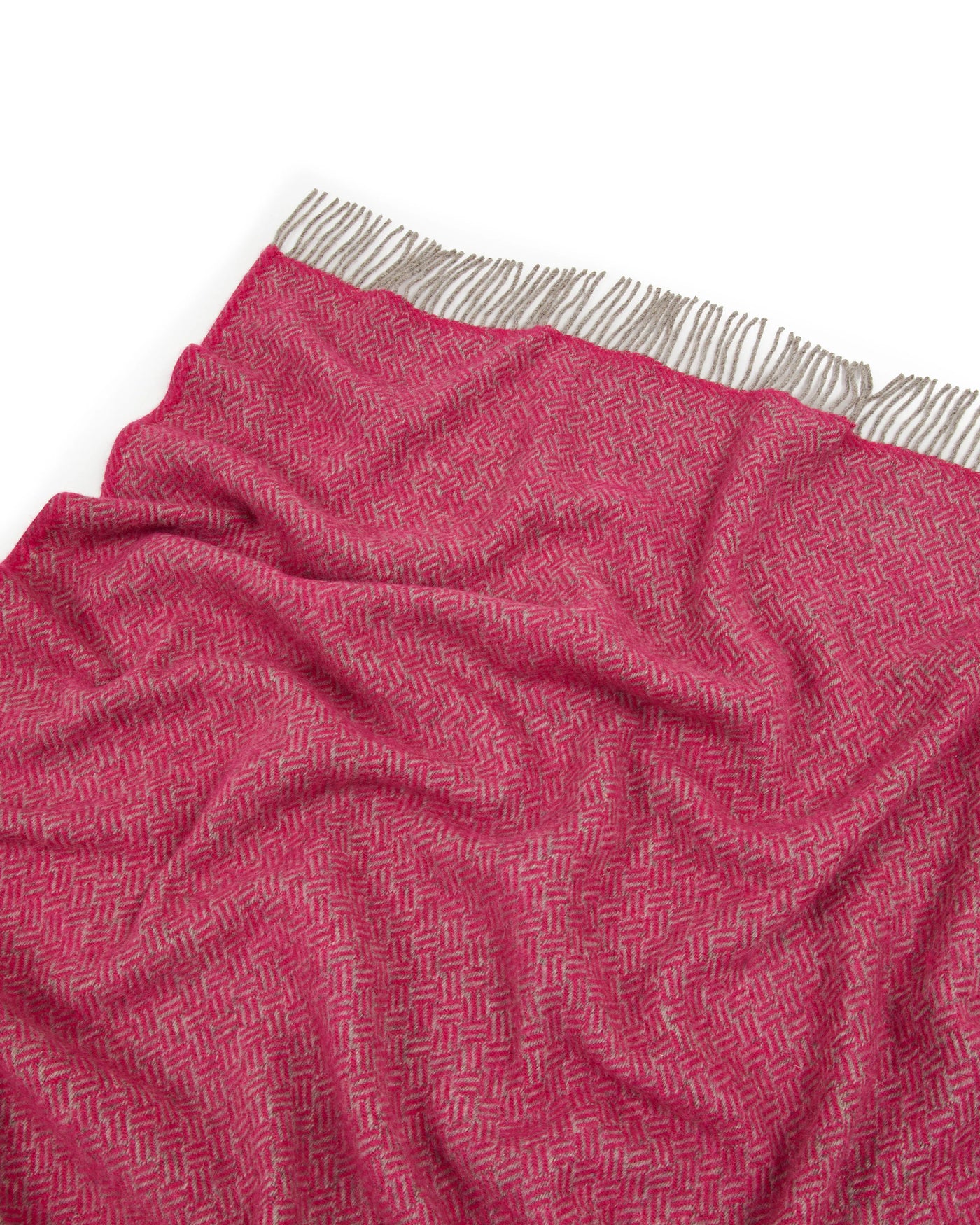 Close-up of Lanerossi Mata Mata throw in raspberry, showing herringbone weave texture and fringe edge.