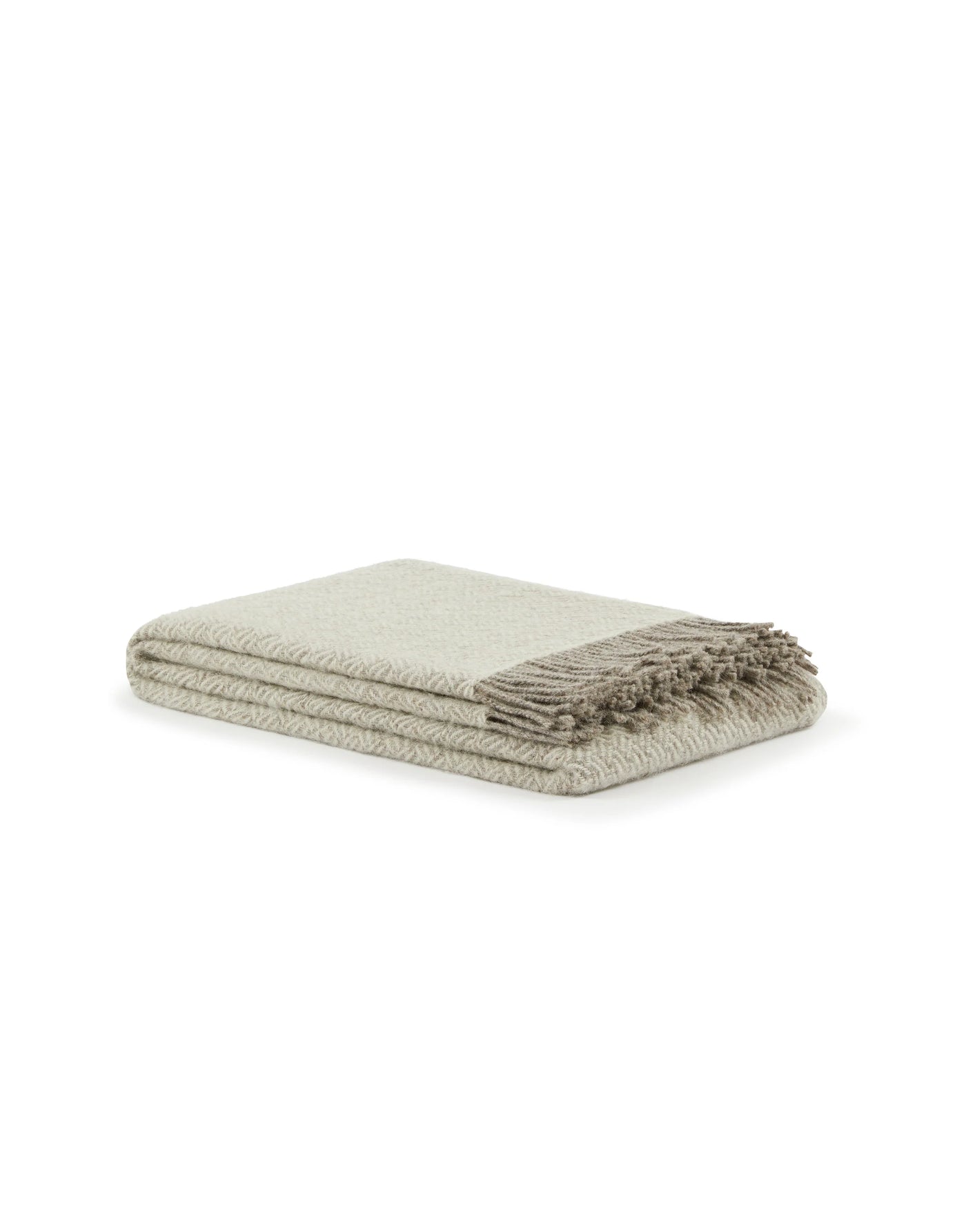 Folded sage throw with woven herringbone texture and knotted fringe trim.