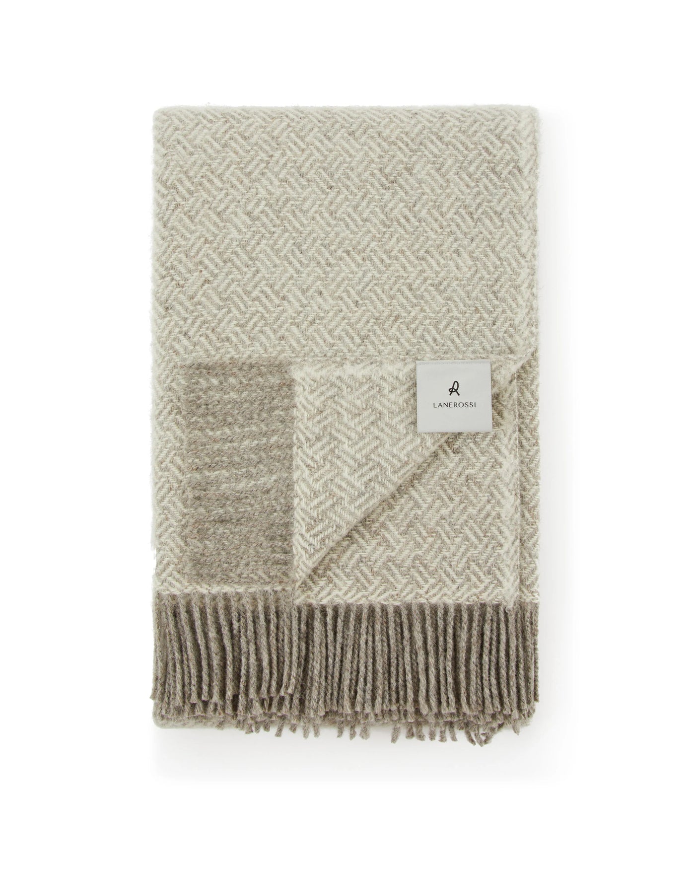 Close-up of folded Lanerossi Mata Mata throw in ivory and taupe herringbone with fringe hem.