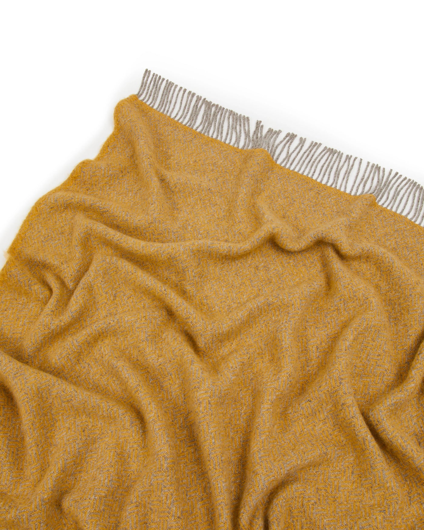 Close-up of Lanerossi Mata Mata throw in saffron with fringe trim detail.