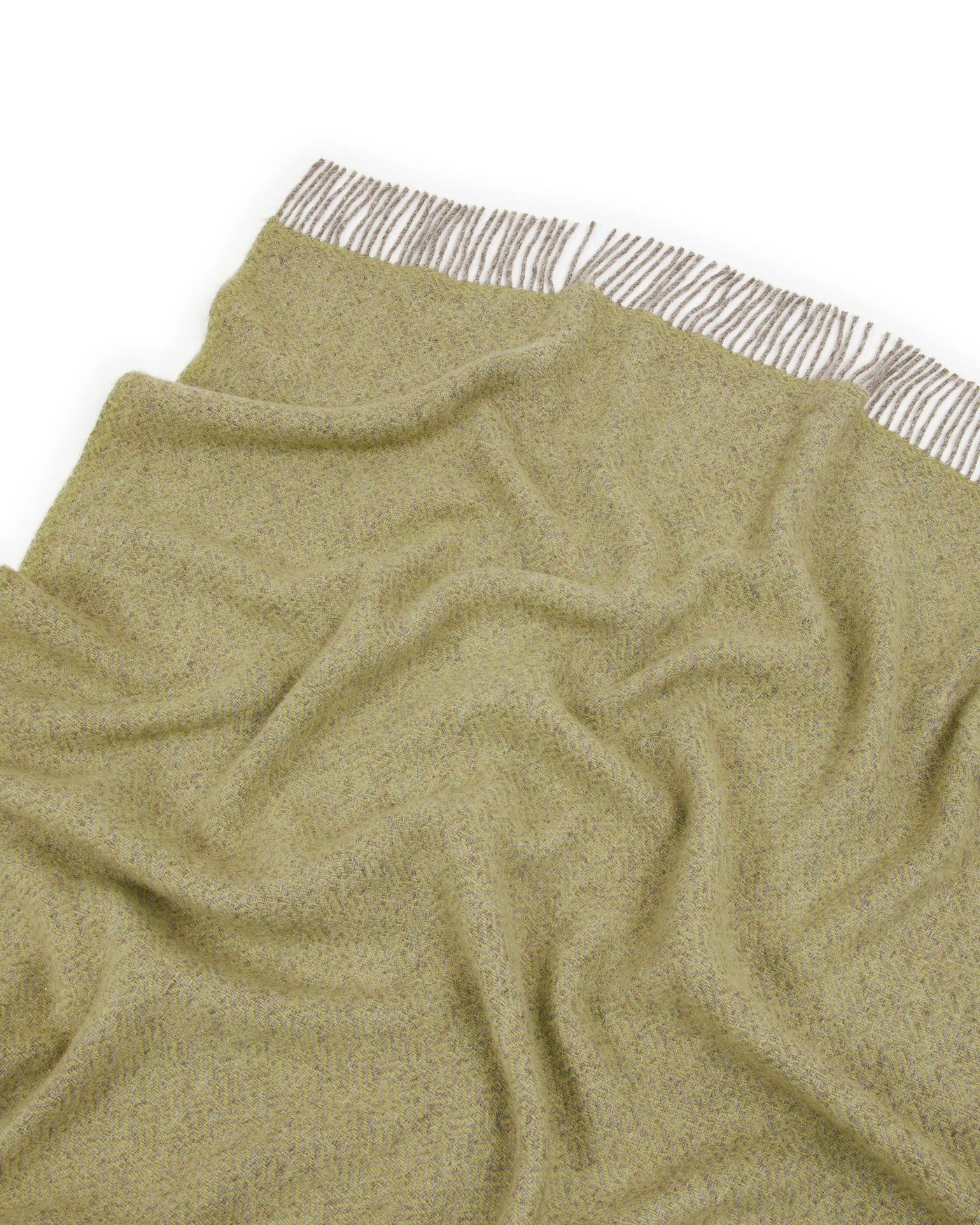 Olive green boucle throw draped loosely, striped fringe detail visible along top edge.