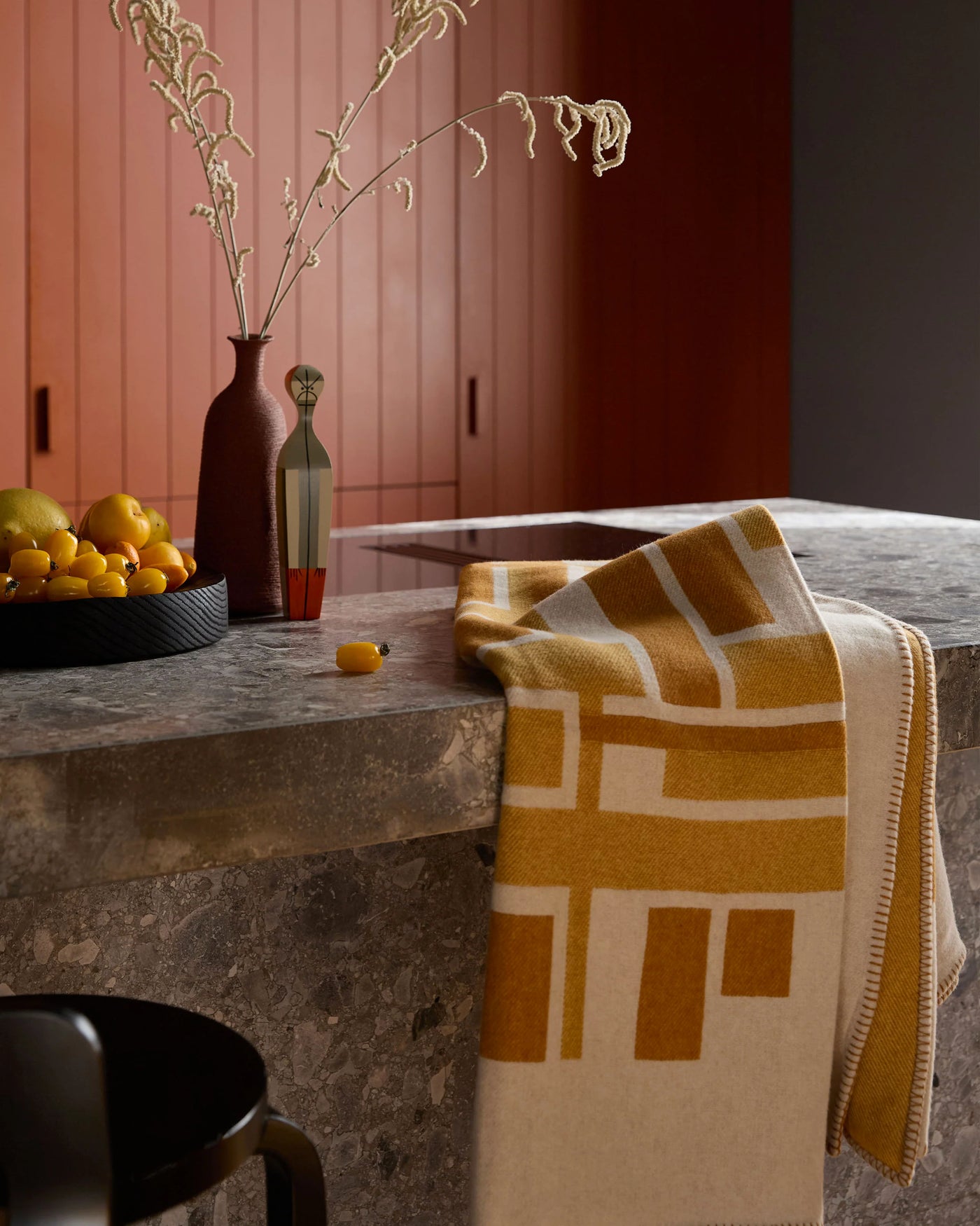 Lanerossi Metropolis throw in mustard and ivory geometric pattern draped over stone counter.