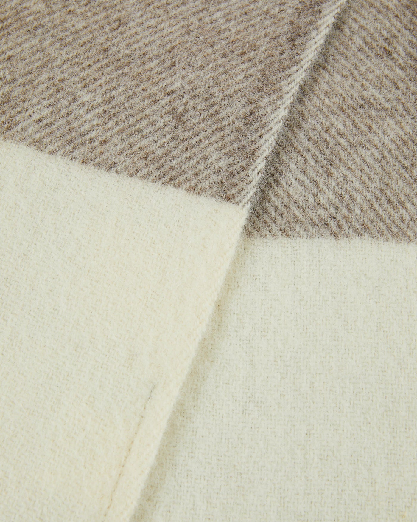 Close-up of Lanerossi Nelson throw corner fold, ivory and taupe colorblock wool weave.