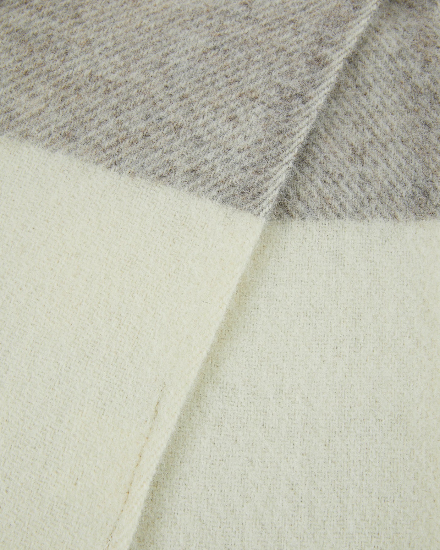 Close-up of Lanerossi Nelson throw corner, ivory and grey colorblock wool weave.
