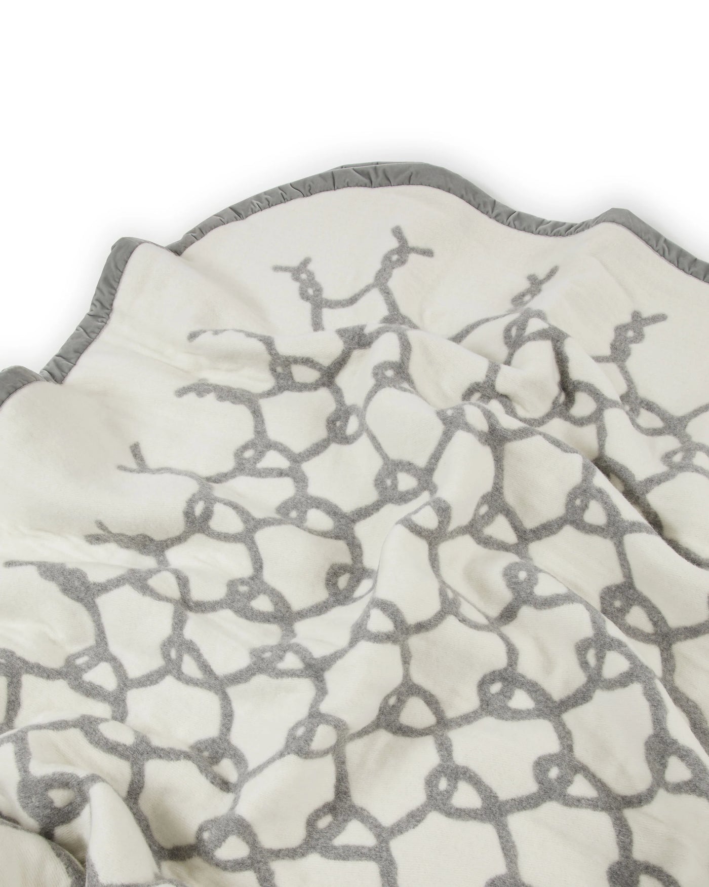 Close-up of Lanerossi Net blanket in ivory with grey rope-knot pattern and scalloped trim.