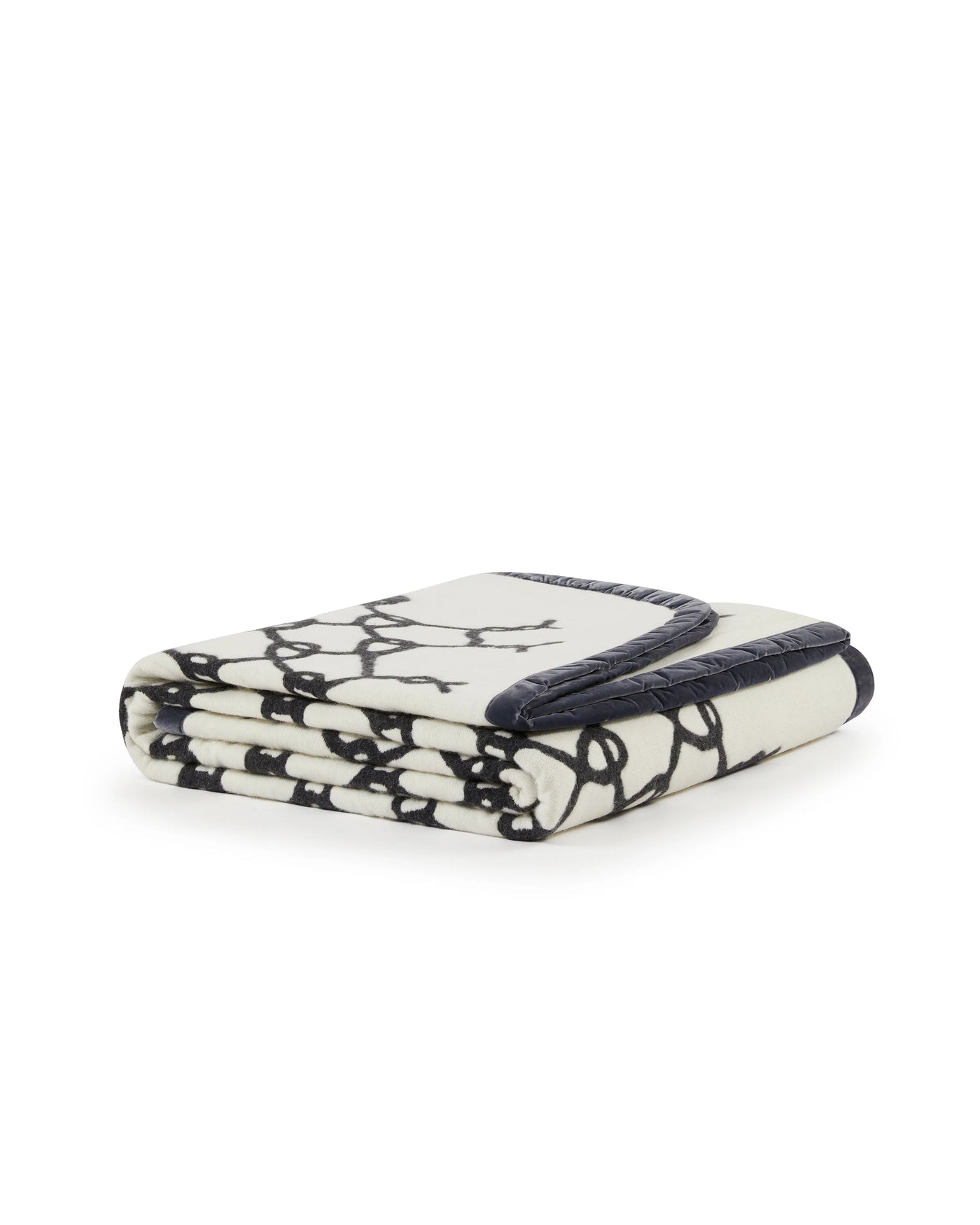 Folded ivory blanket with navy Net pattern and quilted navy border trim.