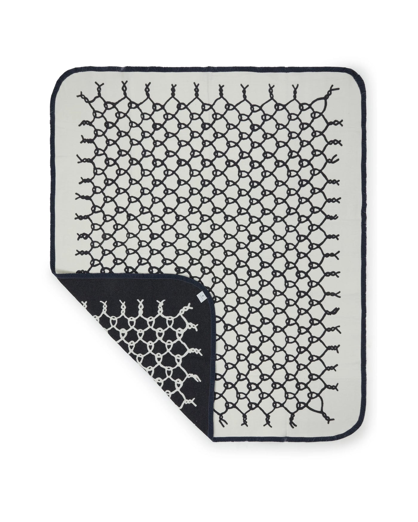 Lanerossi Net blanket corner folded back, revealing navy reverse side of ivory knit.