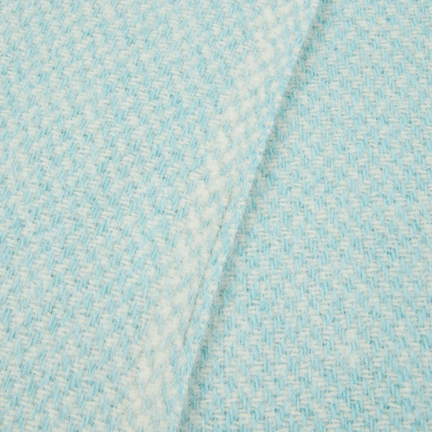 Close-up of Lanerossi Northland throw in aqua, showing woven texture and folded edge.