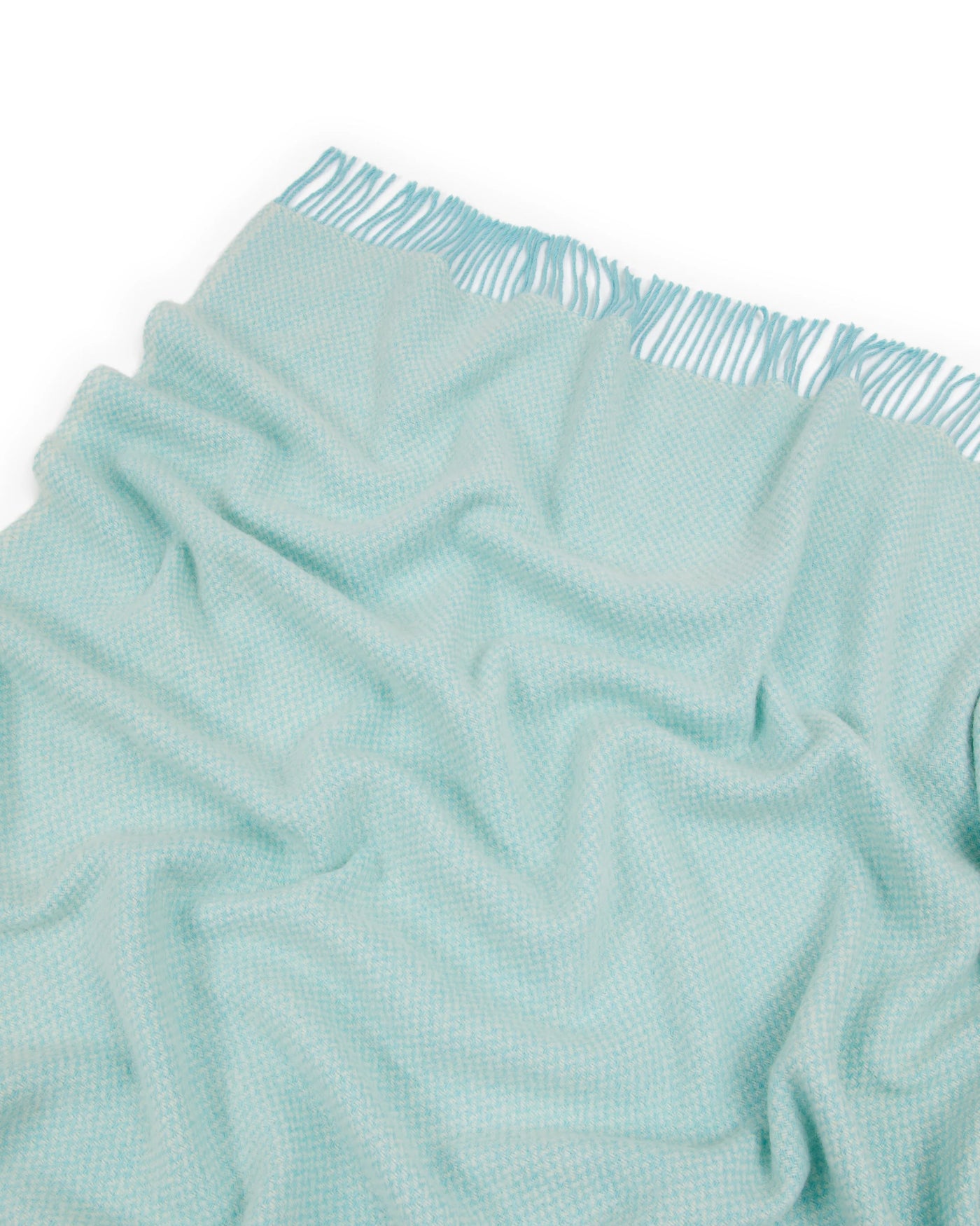 Close-up of Lanerossi Northland throw in aqua, showing woven texture and fringe edge detail.