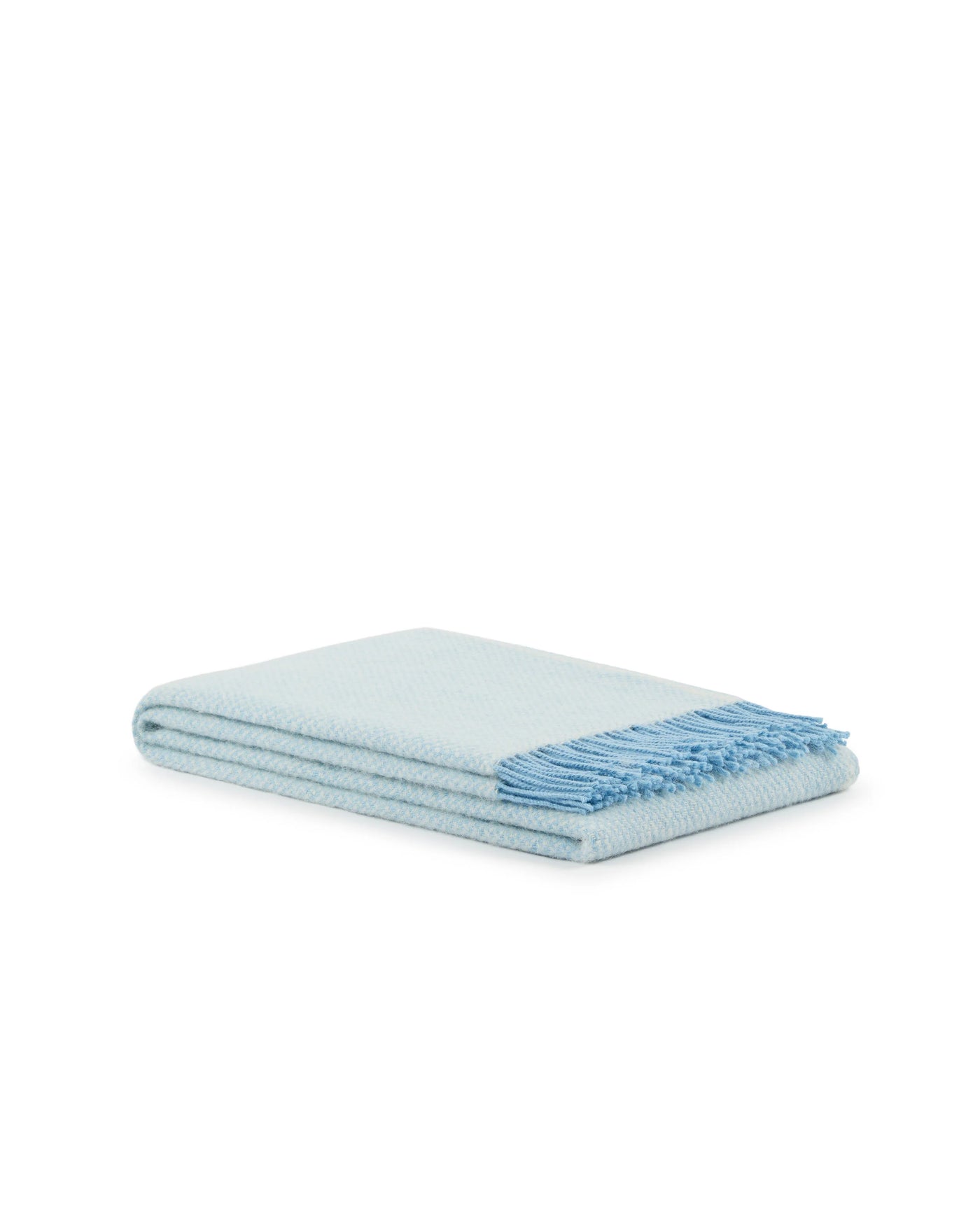 Folded pale blue throw with fringed edge, showing woven texture detail.