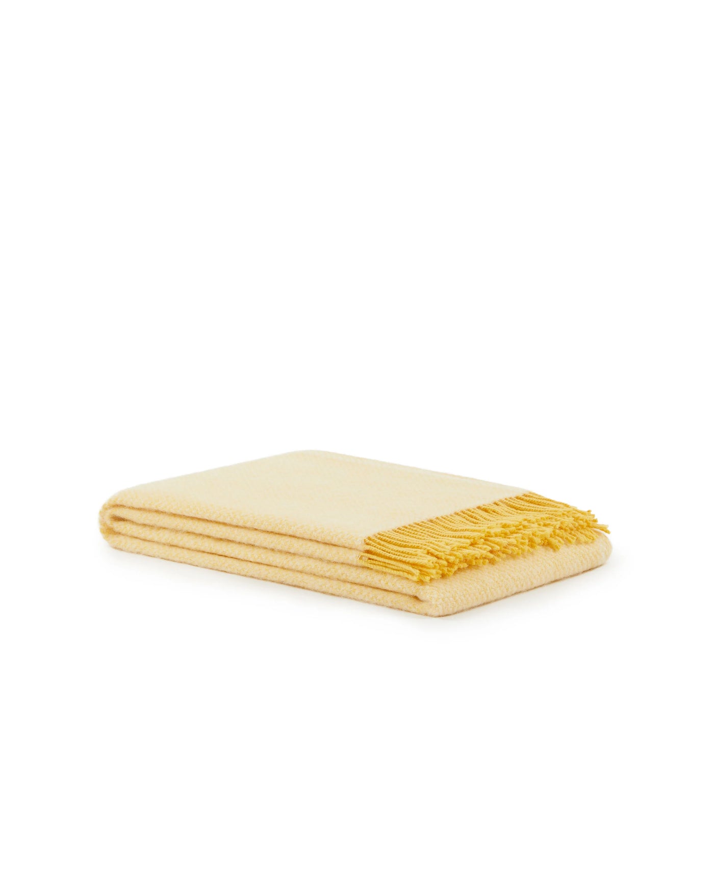Folded ivory wool throw with contrasting marigold fringe trim along one edge.