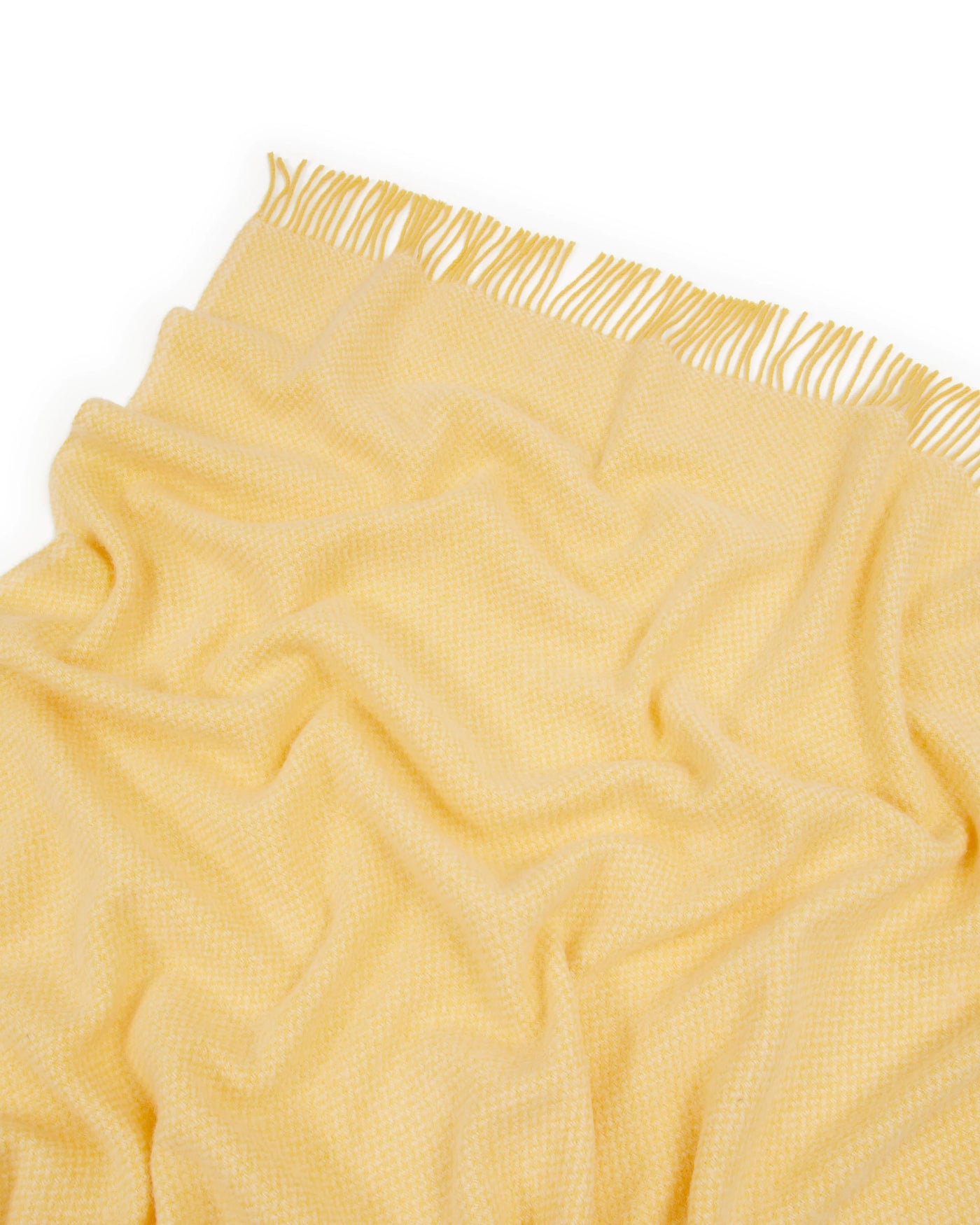 Close-up of Lanerossi Northland throw in buttercup yellow, showing woven texture and fringe trim.