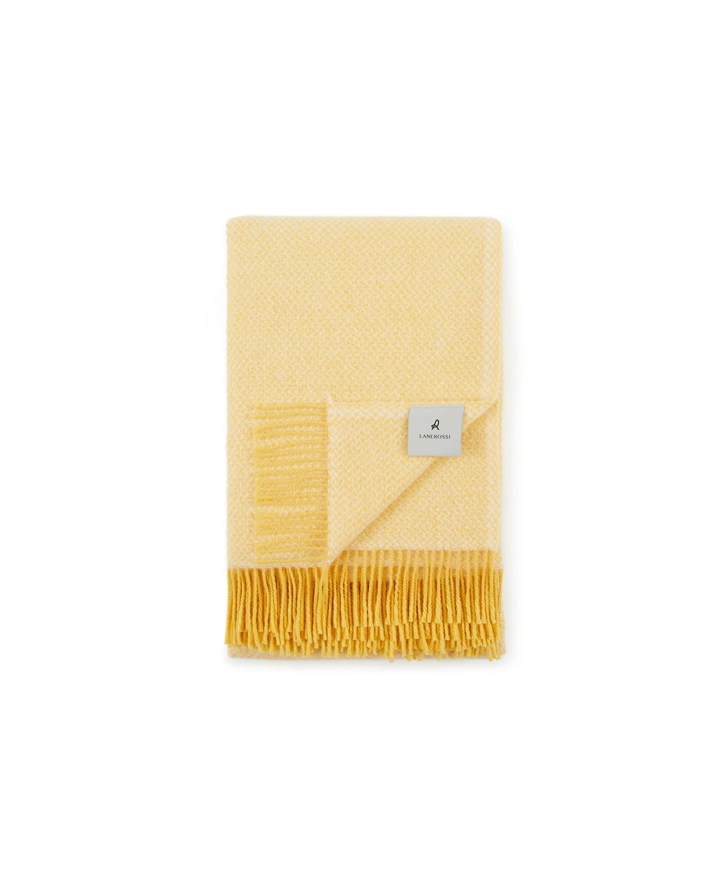 Folded Lanerossi Northland throw in butter yellow with woven texture and fringed hem.